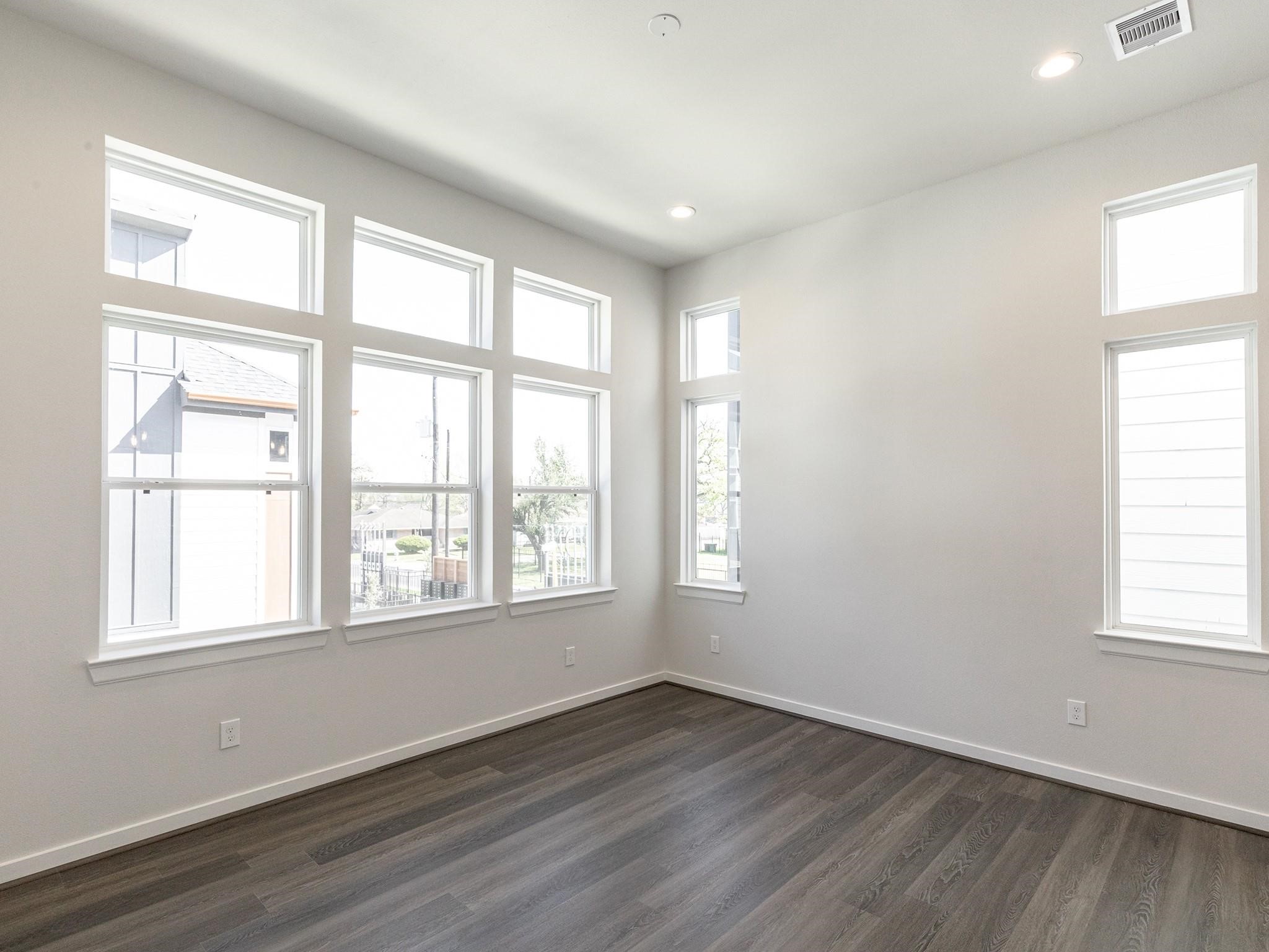 Bright and inviting room with abundant natural light streaming through multiple large windows, complemented by luxury vinyl plank flooring and recessed lighting.
Note: Photos 2022 Bright and inviting room with abundant natural light streaming through multiple large windows, complemented by luxury vinyl plank flooring and recessed lighting.
Note: Photos 2022