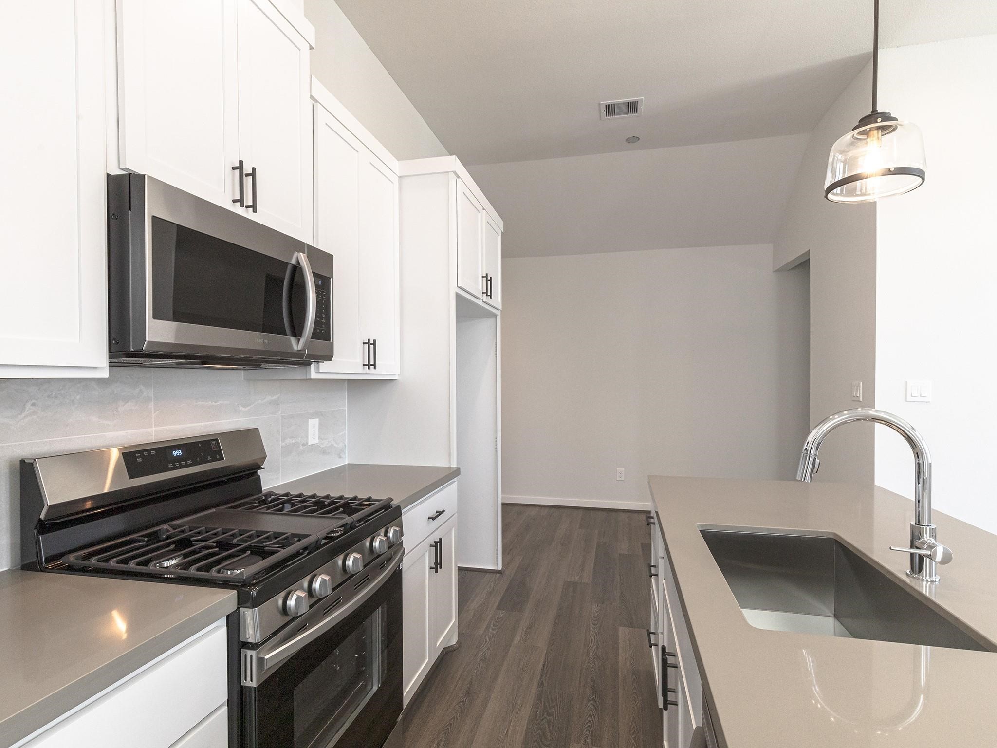 Modern kitchen featuring sleek stainless steel appliances, elegant white cabinetry, and a spacious island with a stylish pendant light.
Note: Photos 2022 Modern kitchen featuring sleek stainless steel appliances, elegant white cabinetry, and a spacious island with a stylish pendant light.
Note: Photos 2022