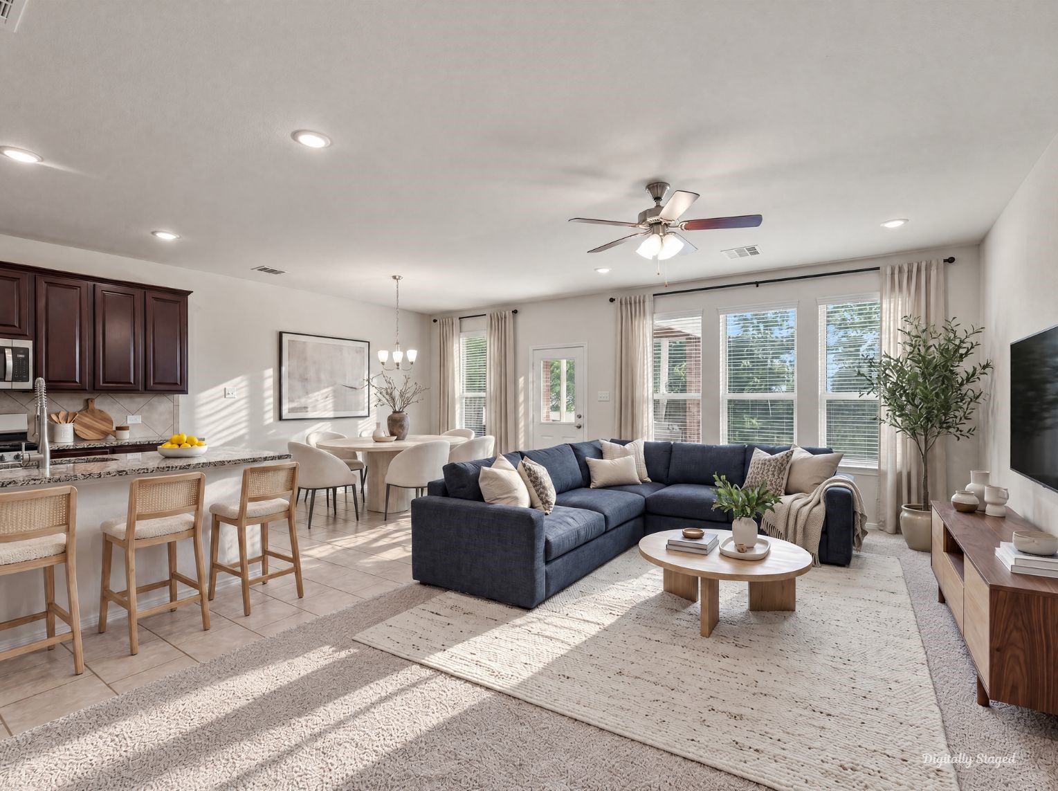 Open-concept main living area connecting the kitchen, dining space, and living room under recessed lighting and a ceiling fan. A wall of windows fills the space with natural light and easy backyard views.
This photo has been digitally staged to illustrate the possibilities of the homes aesthetic and potential design. Some furnishings and dcor shown are for visual inspiration.