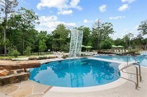 A dedicated dive pool with a rock climbing wall provides a safe and exciting water play space for children, conveniently located adjacent to the main pool and shaded seating.