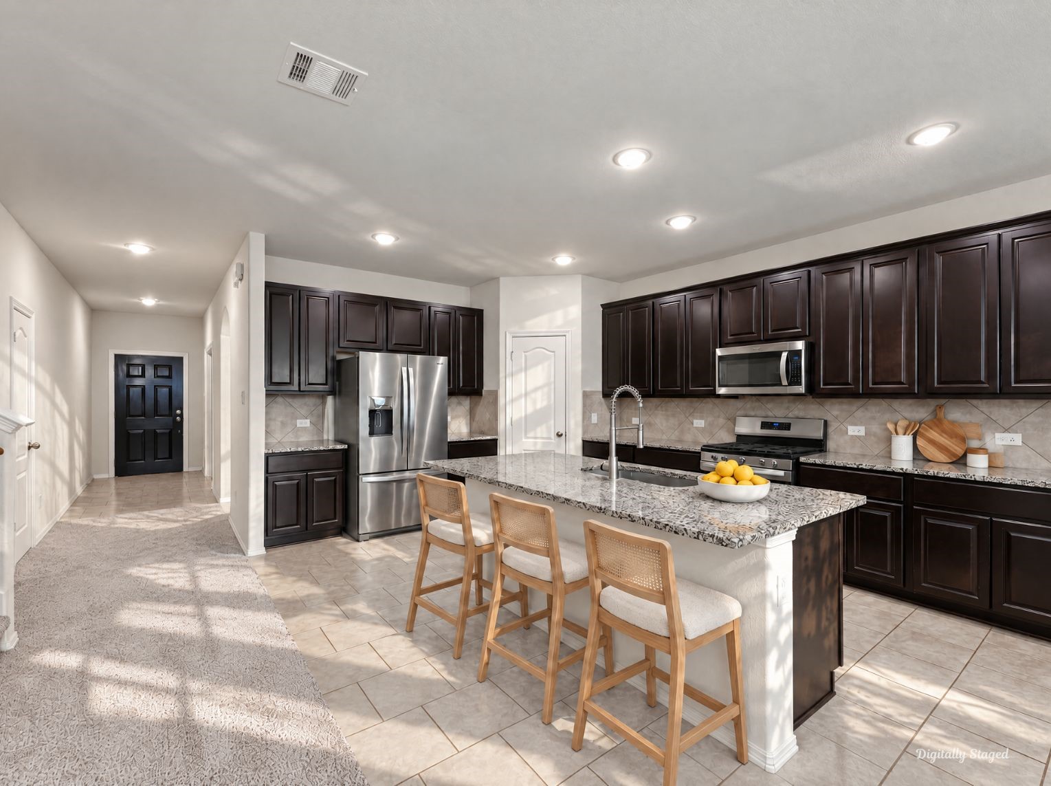 Kitchen with abundant dark raised-panel cabinetry, recessed lighting, and ample granite counter space. The large island anchors the room and keeps the layout open and functional.
This photo has been digitally staged to illustrate the possibilities of the homes aesthetic and potential design. Some furnishings and dcor shown are for visual inspiration.