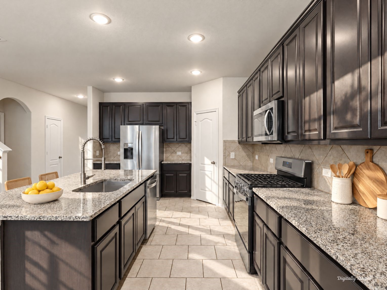 Well-appointed kitchen featuring granite counters, an island with an undermount sink, and a pull-down sprayer faucet. A gas range, stainless steel appliances, and tile backsplash complete the look.
This photo has been digitally staged to illustrate the possibilities of the homes aesthetic and potential design. Some furnishings and dcor shown are for visual inspiration.