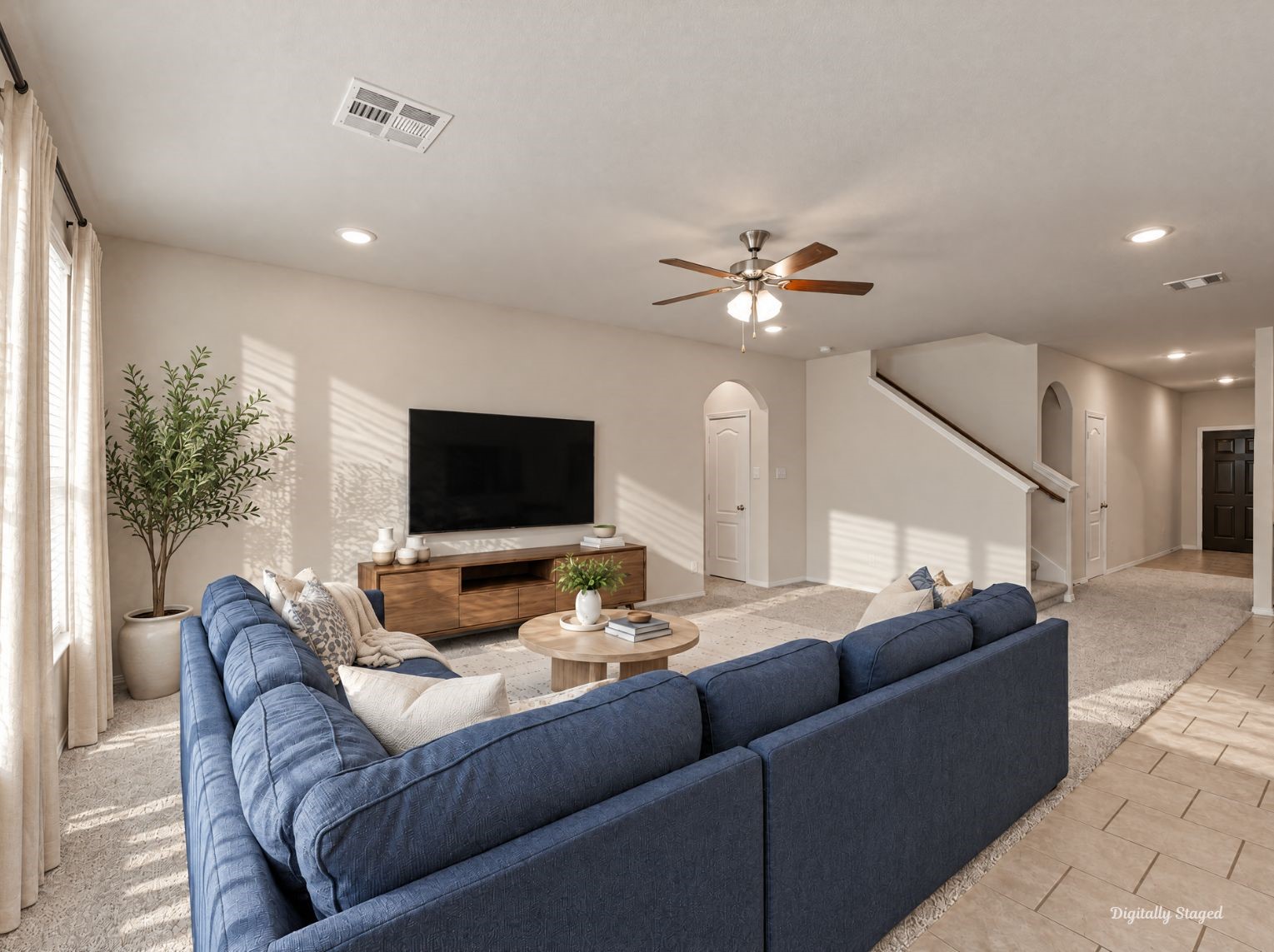 Roomy living area with soft carpet and tile flooring that flows toward the entry. Arched alcoves and a staircase with a wood handrail add architectural interest.
This photo has been digitally staged to illustrate the possibilities of the homes aesthetic and potential design. Some furnishings and dcor shown are for visual inspiration.