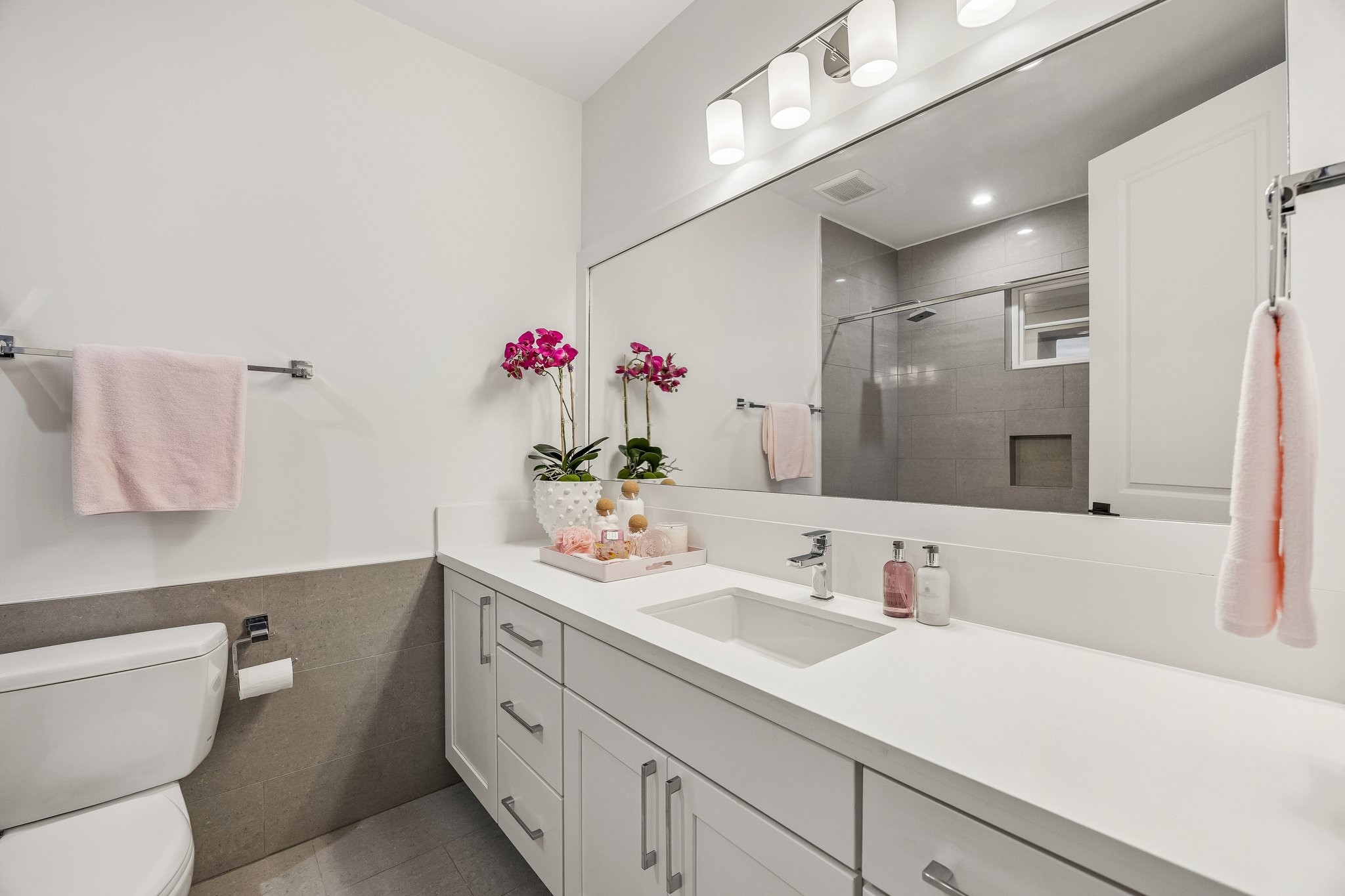 Generous size en-suite baths in all bedrooms.  Shaker style cabinetry, slab quartz counter,underount sink, framed mirror and pedent lighting.