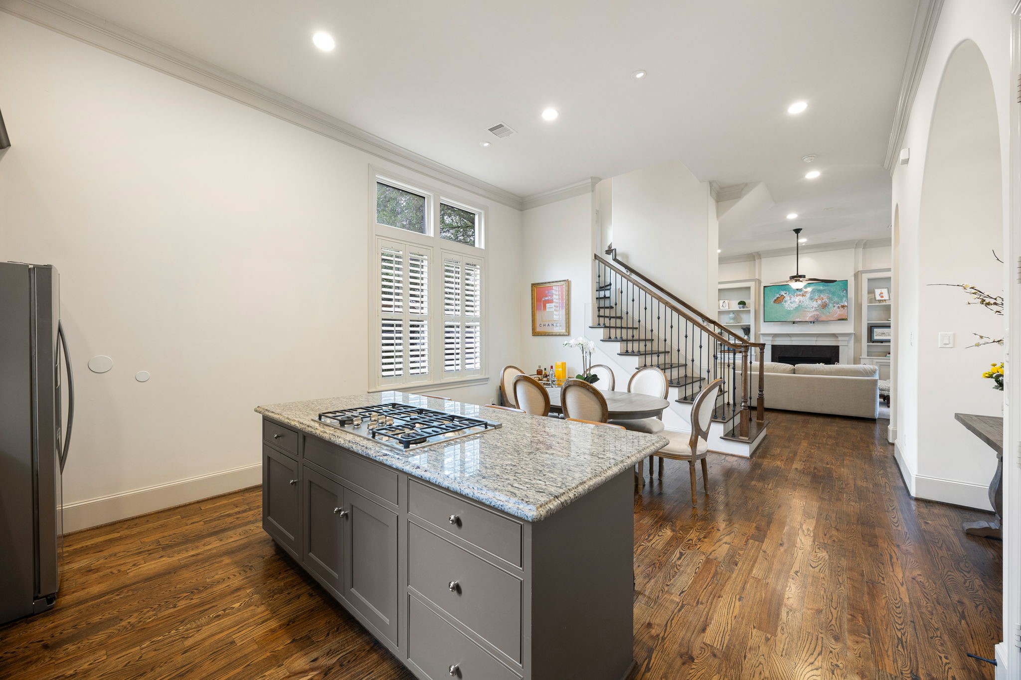 The open-concept floor plan flows seamlessly into a dining area and living room perfect for hosting or enjoying time with family.  The hardwood floors, 12' ceilings through out give such an elevated feel.  The staircase leads to the upstairs bedrooms.
