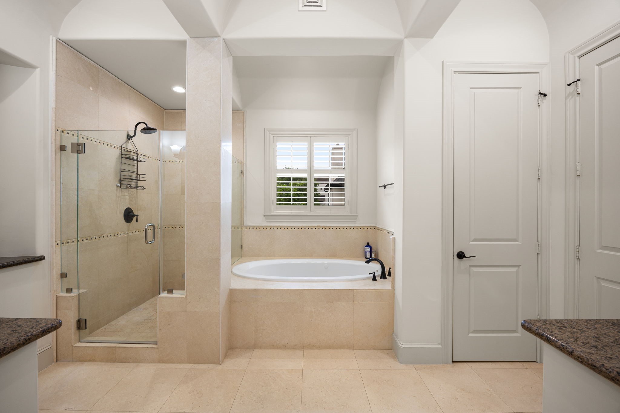The primary bathroom has dual vanities and a water jetted bath tub.