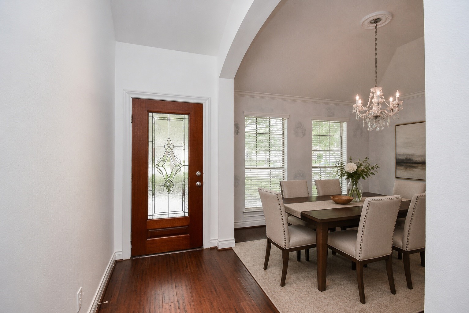 Step inside to a bright and welcoming entry that opens to an elegant formal dining room, thoughtfully designed for everyday meals or special gatherings. Warm wood flooring, abundant natural light, and soaring ceilings create an inviting first impression. Virtually staged.