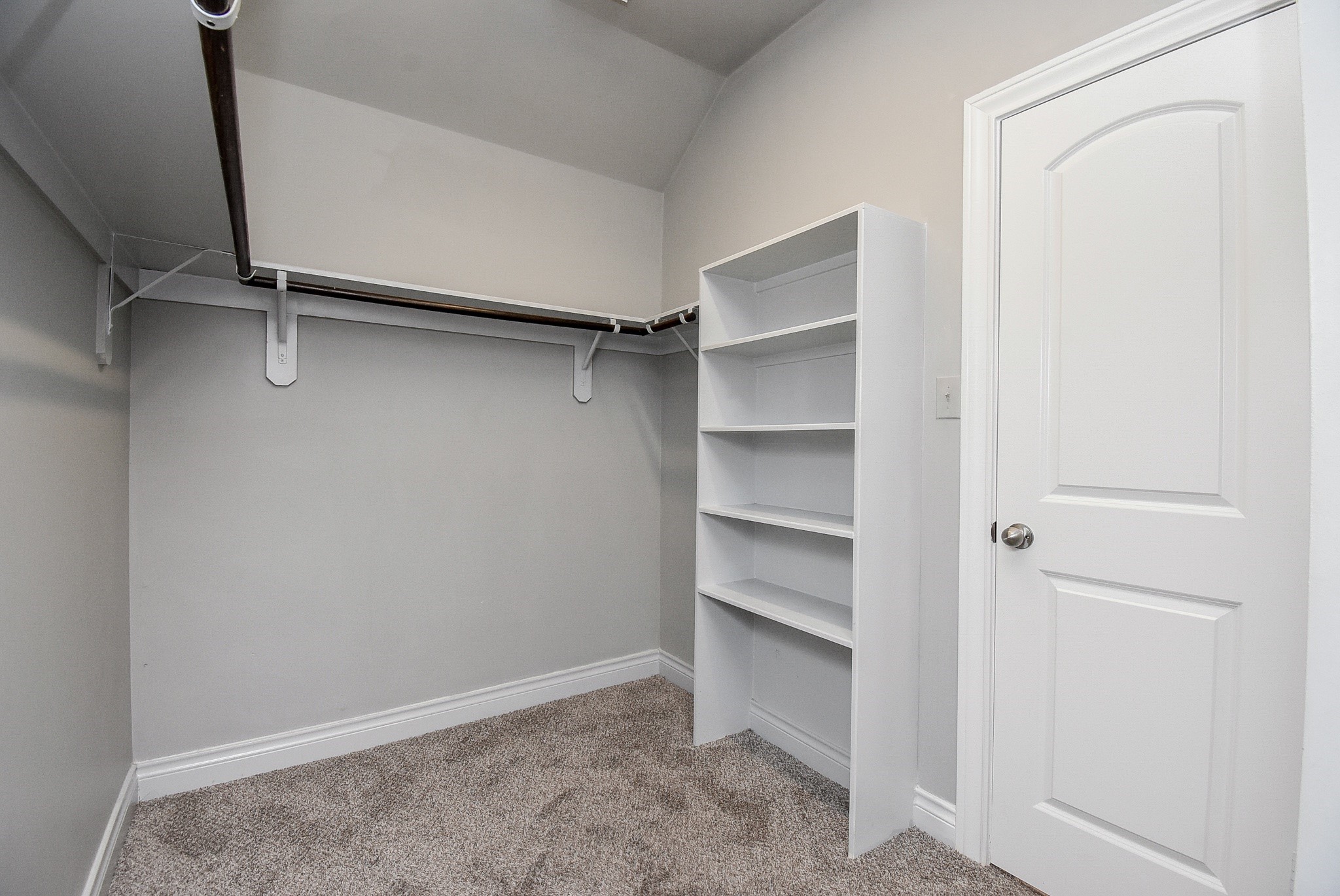 Designed for effortless organization, the spacious primary walk-in closet offers generous hanging space, built-in shelving, and a functional layout to accommodate wardrobes of all sizes. High ceilings enhance the open feel, while the thoughtfully designed storage solutions make it easy to keep everything organized and within reach. A perfect extension of the private primary suite, combining everyday convenience with exceptional storage.