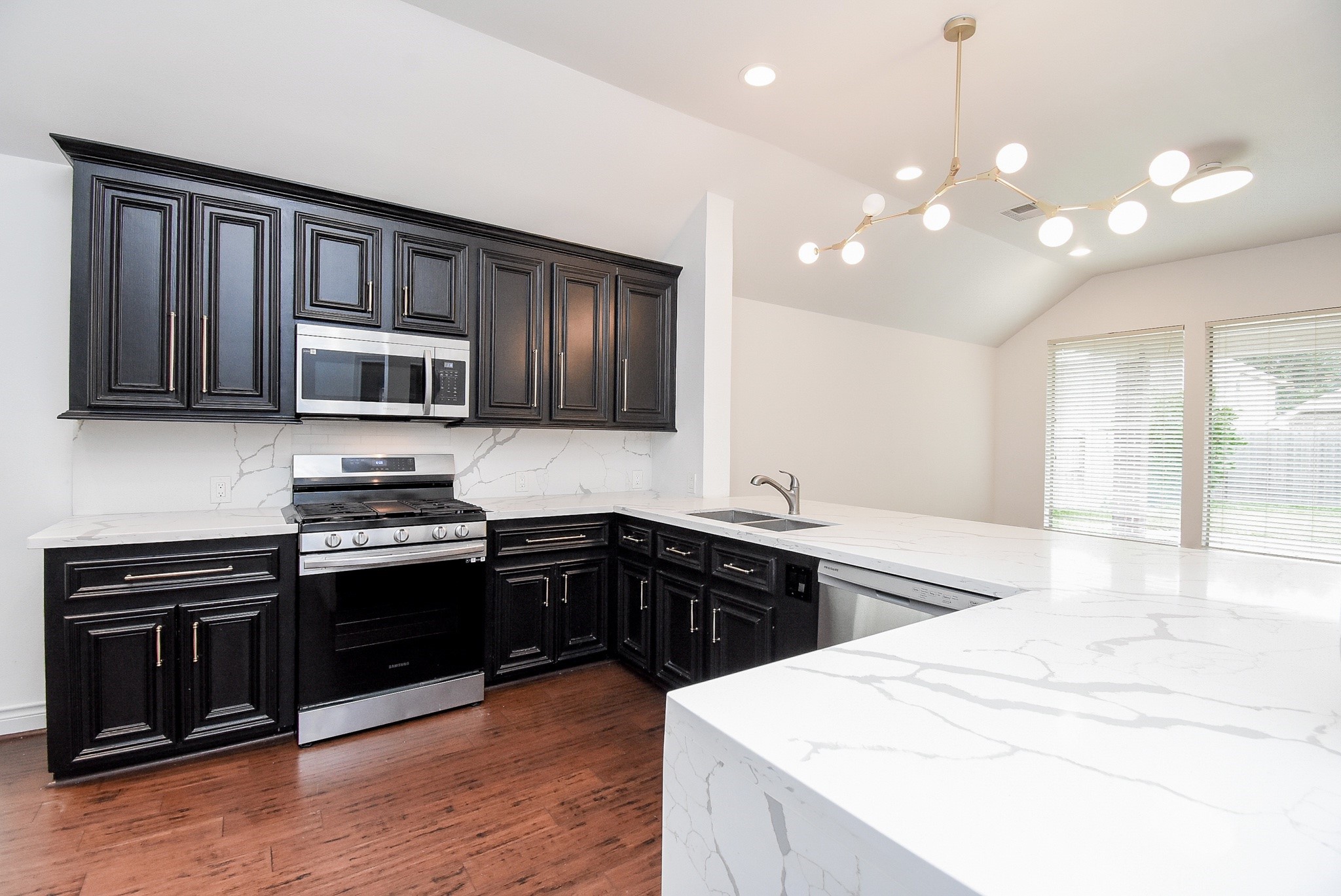 Designed for both everyday living and entertaining, this beautifully appointed kitchen features elegant quartz countertops, rich cabinetry, stainless steel appliances, and an expansive breakfast bar. The open-concept layout flows effortlessly into the breakfast area, creating a bright and inviting space for gathering with family and friends.