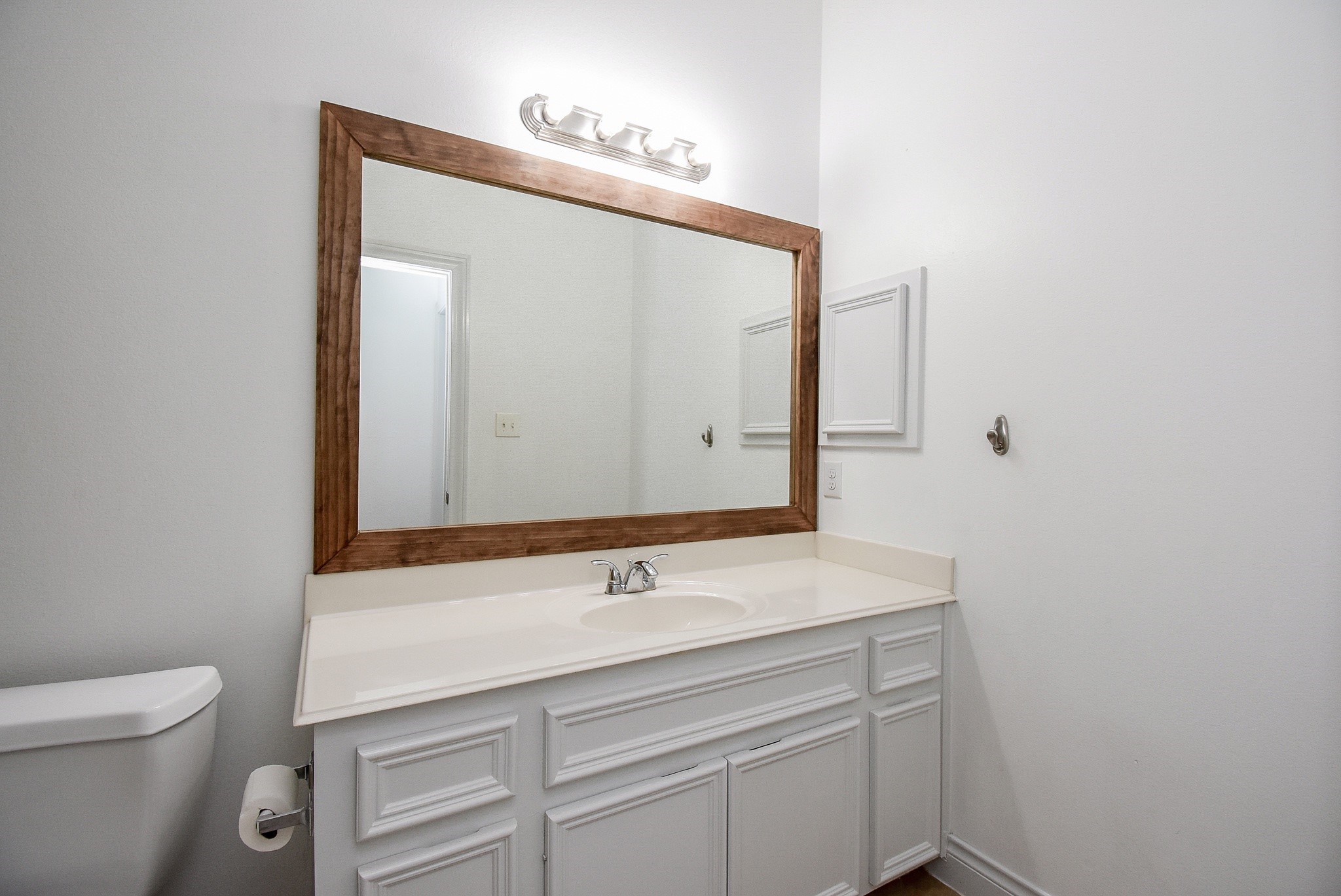 Bathroom No. 2 features a spacious single-sink vanity with an extended countertop, offering ample space for everyday convenience. The oversized framed mirror enhances the room's bright and airy feel, while generous cabinetry provides excellent storage. Clean finishes and a neutral color palette make this bathroom both functional and inviting for family or guests.