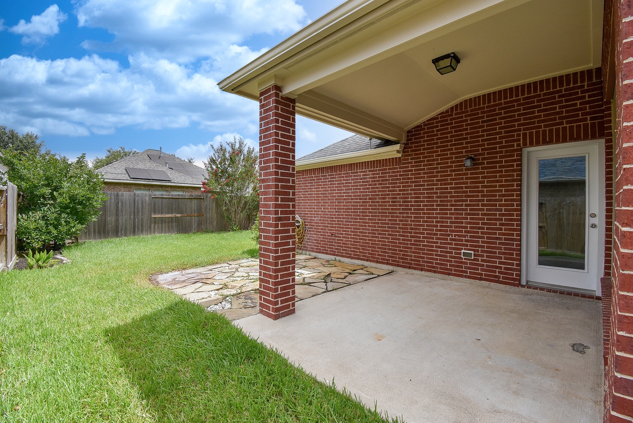 Step outside to a covered patio designed for year-round outdoor enjoyment. This inviting space is perfect for morning coffee, weekend barbecues, or relaxing evenings overlooking the fully fenced backyard. The spacious lawn offers plenty of room for children, pets, or future outdoor enhancements, while the stone patio extension provides additional space for seating or entertaining. A wonderful combination of comfort, privacy, and functionality for everyday outdoor living.