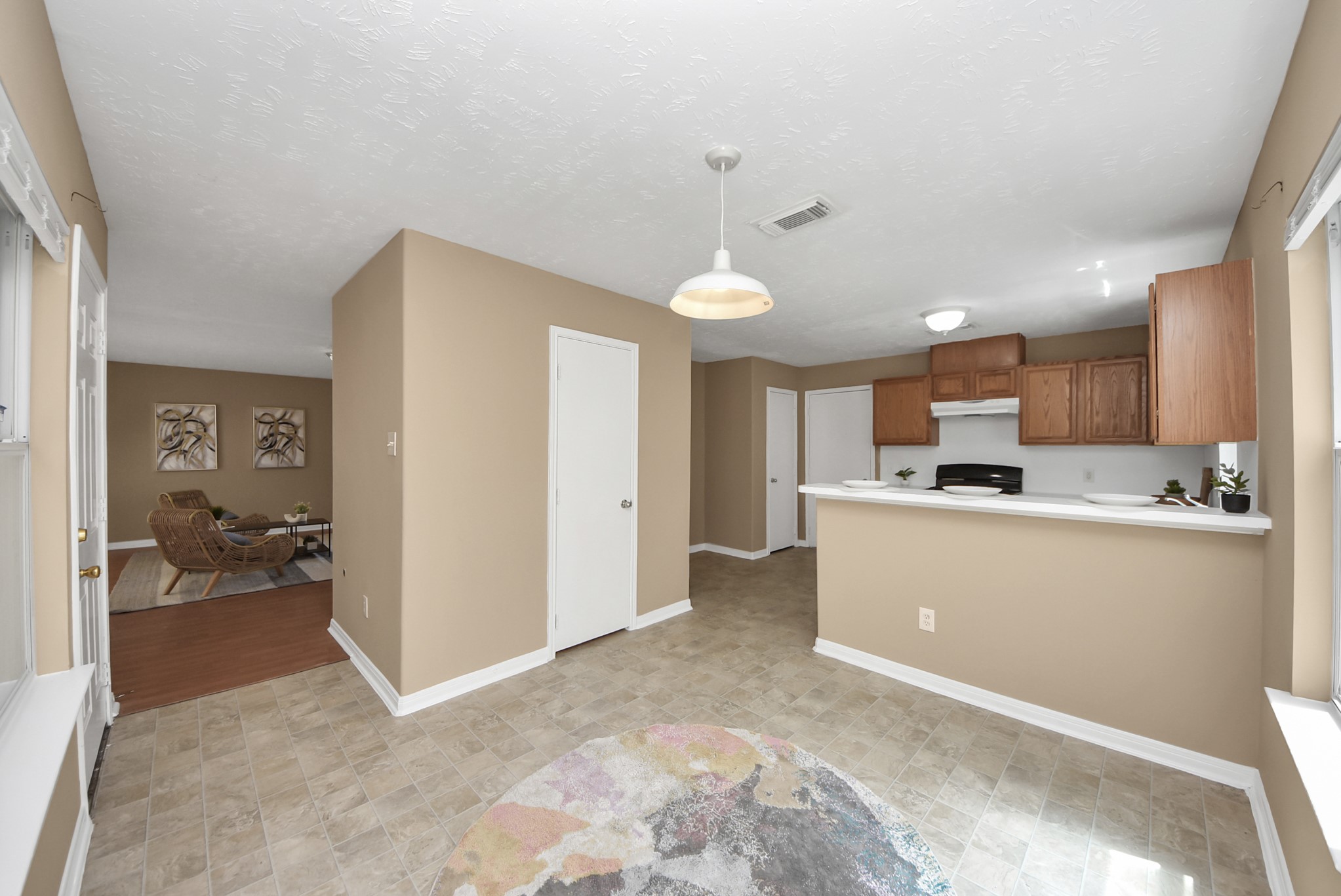 This view looks into the breakfast nook, which also features a convenient peninsula with additional seating. The door across the room leads to the half bathroom.