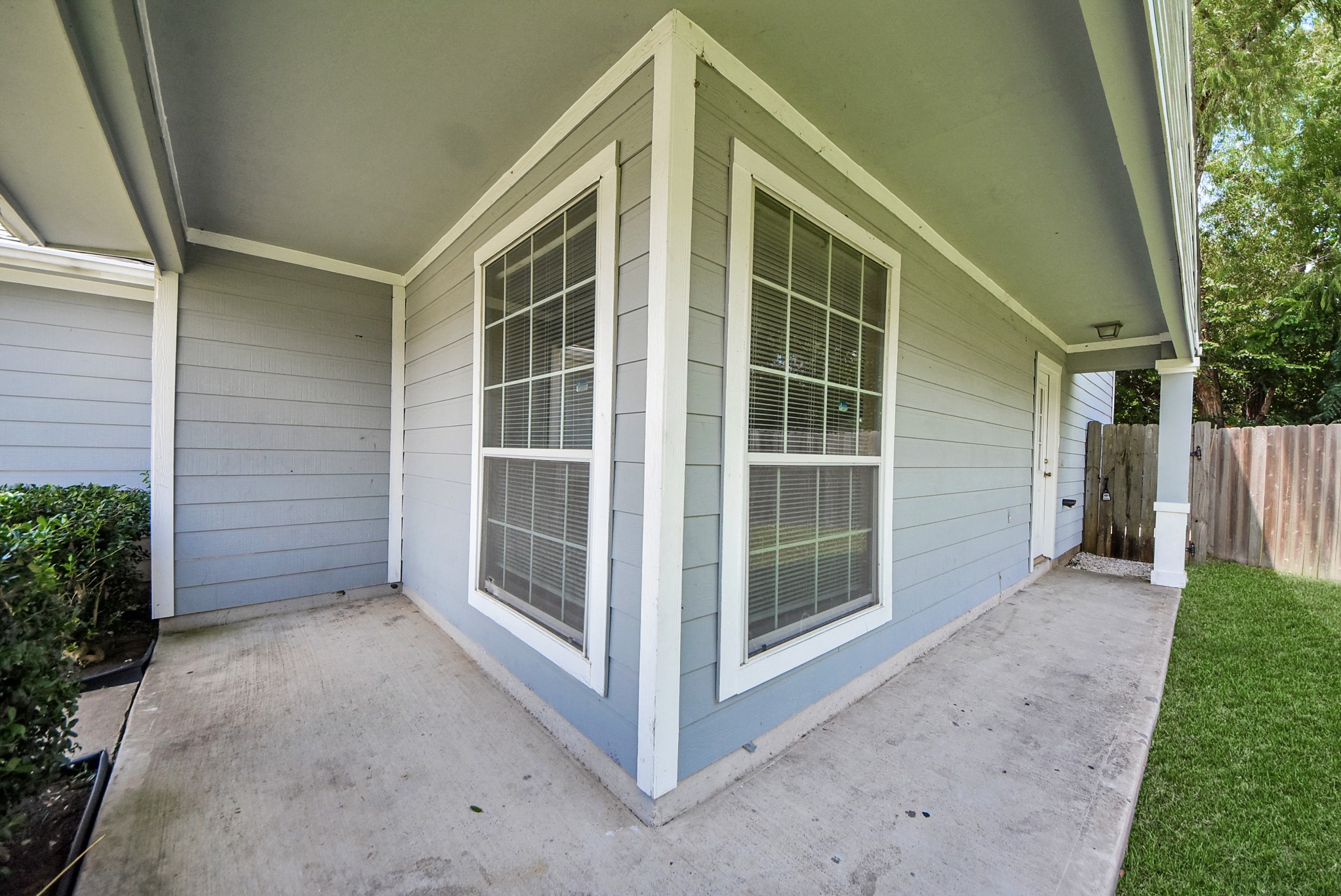 A covered walkway leads to the front door and can also serve as a small, shaded seating area.