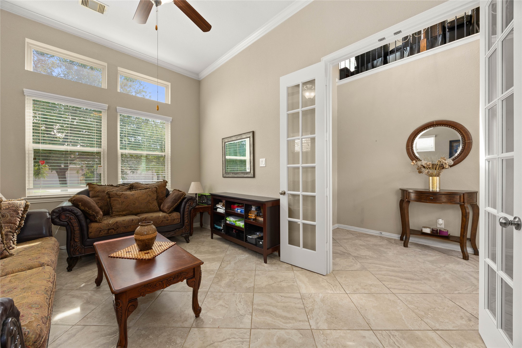 Bright and inviting living room with high ceilings, elegant French doors, and large windows offering plenty of natural light.