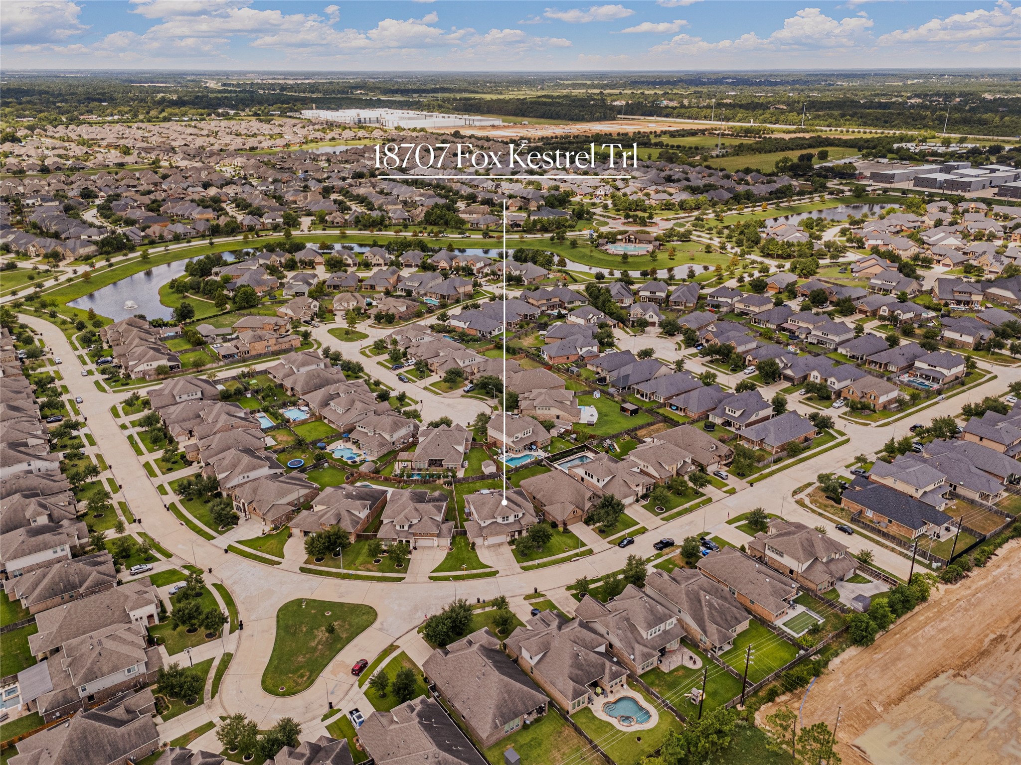 Aerial view of a spacious suburban neighborhood featuring well-kept homes, curving streets, and lush greenery, offering a serene community setting.