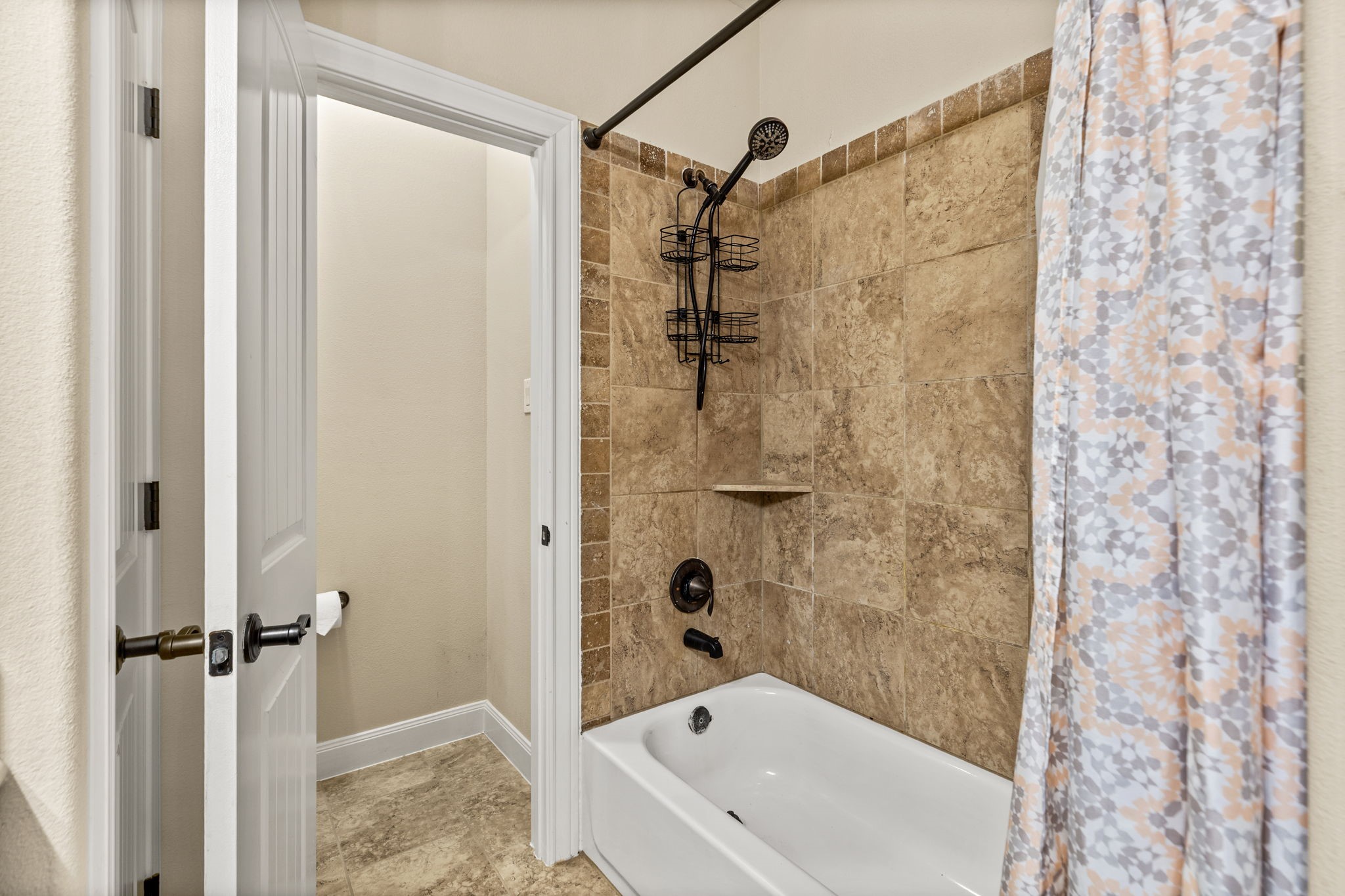 Elegant bathroom with a tiled shower and bathtub, featuring modern fixtures and a stylish shower curtain.