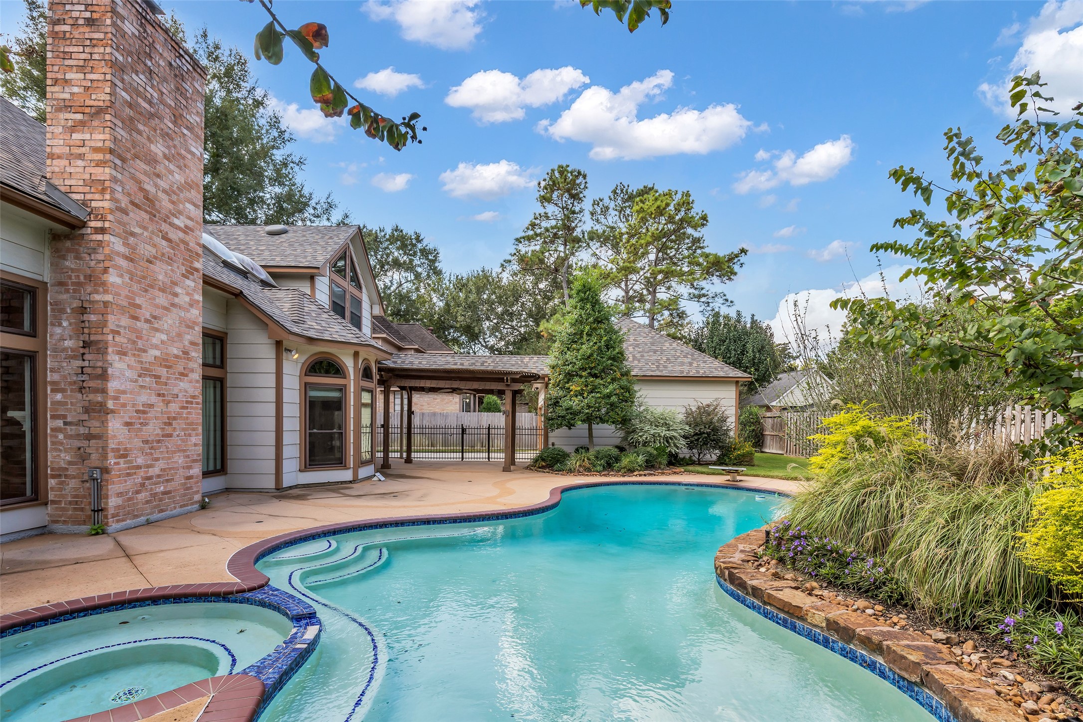 Private pool surrounded by mature landscaping and an expansive patio.