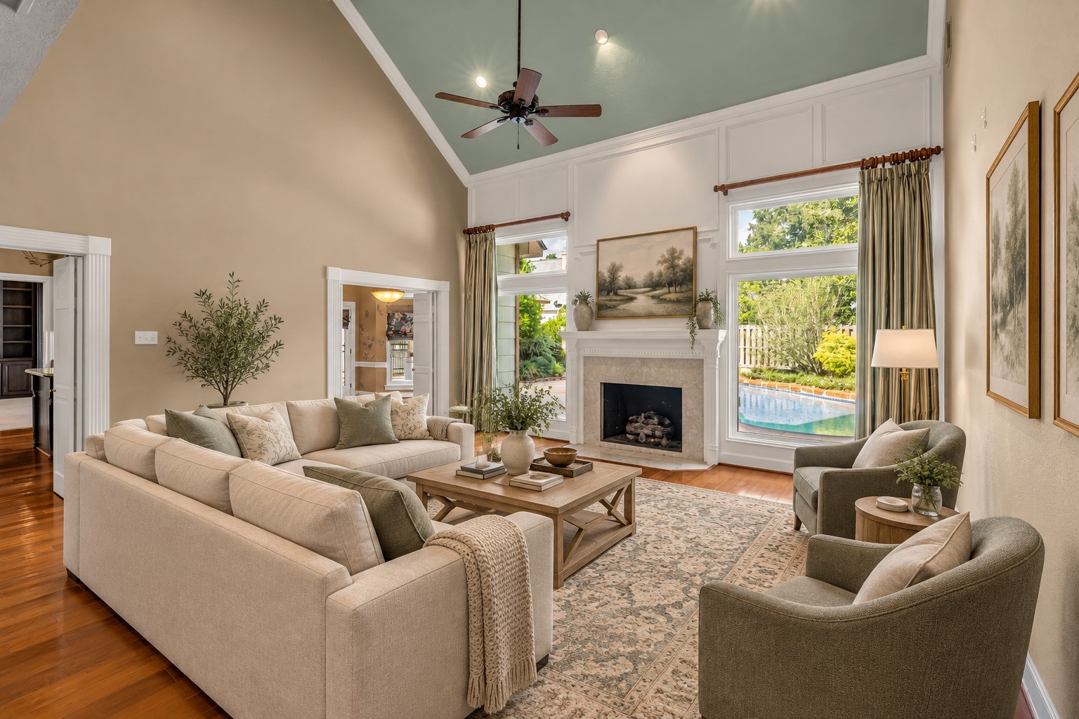 *VIRTUALLY STAGED* Two-story living room with fireplace and views of the private pool.