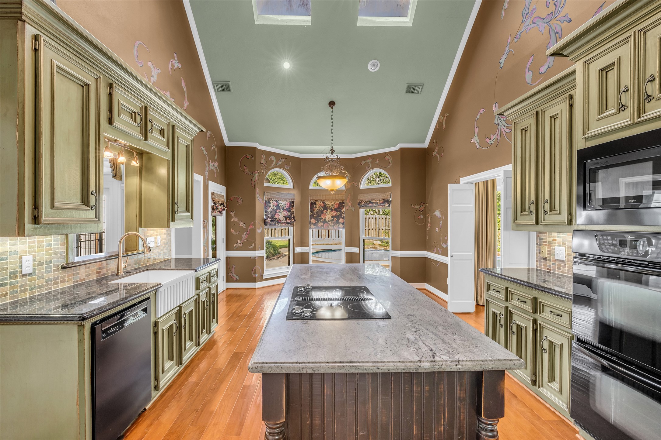Two-story kitchen with large center island, breakfast area, and skylights.