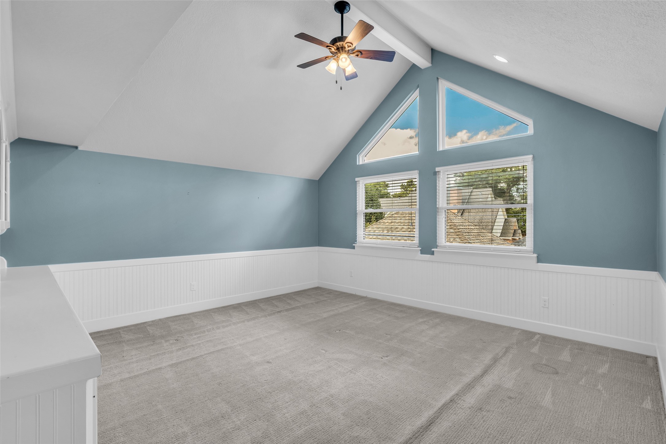 Upstairs game room with vaulted ceiling and built-in shelving.