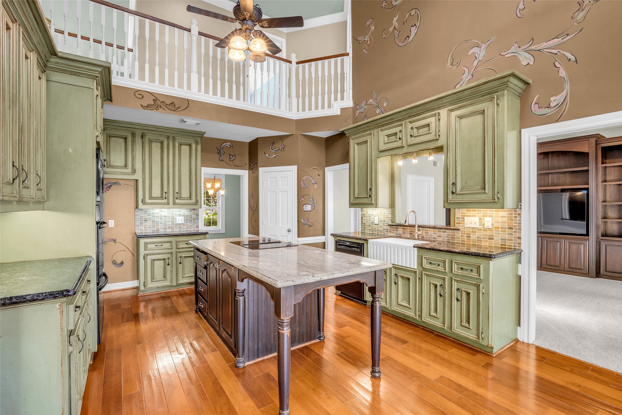 Two-story kitchen with large center island, breakfast area, and skylights.