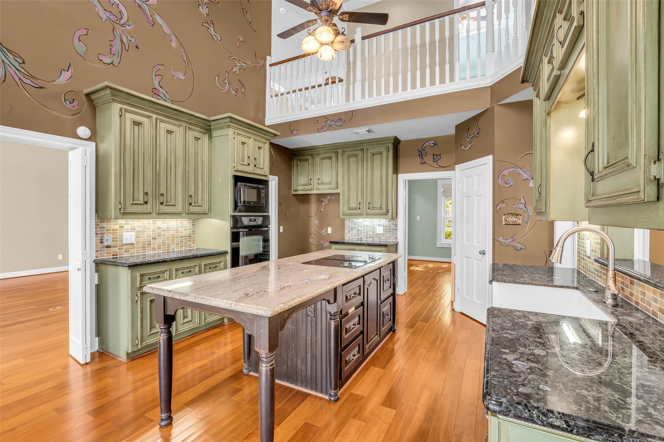 Two-story kitchen with large center island, breakfast area, and skylights.