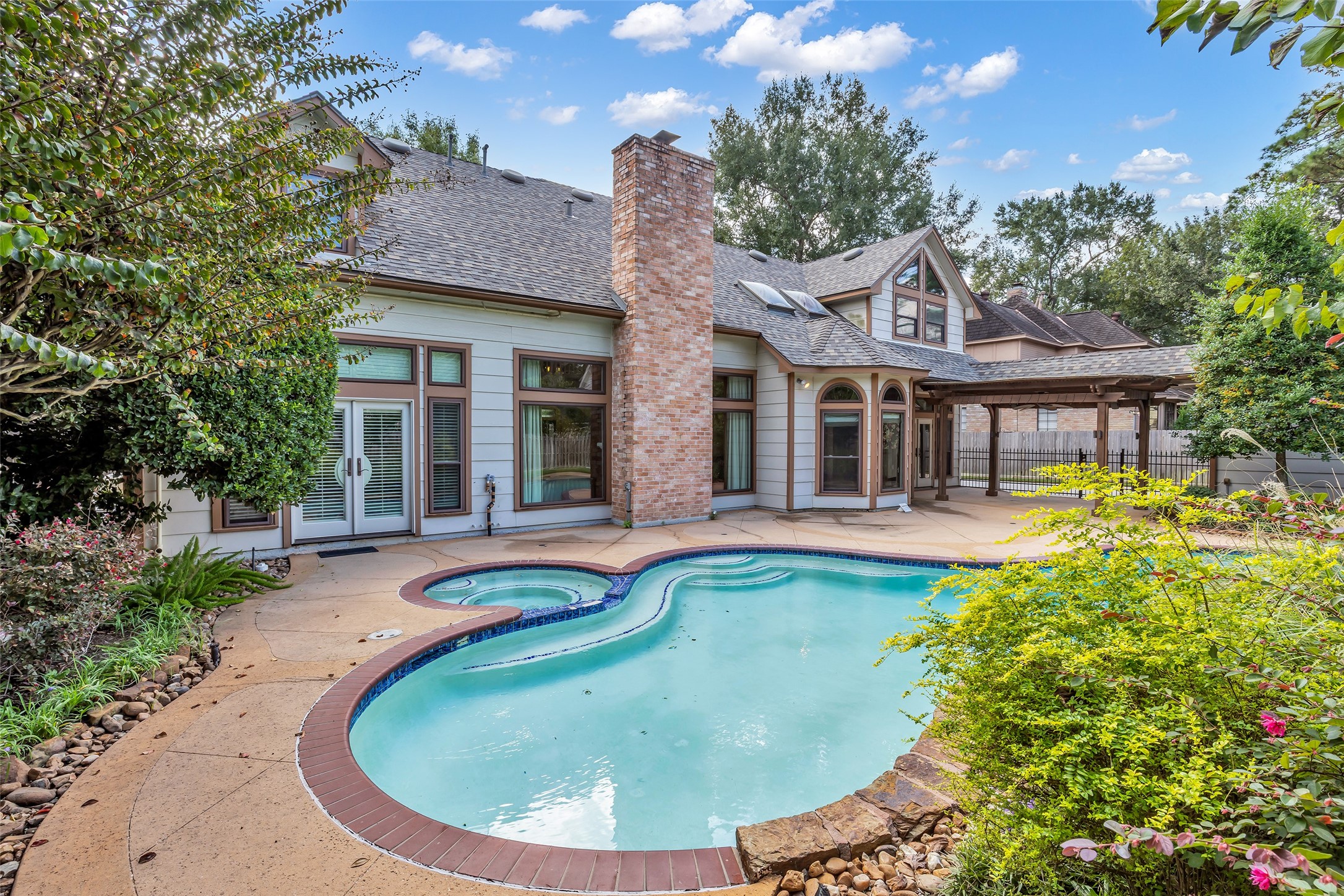 Private pool surrounded by mature landscaping and an expansive patio.