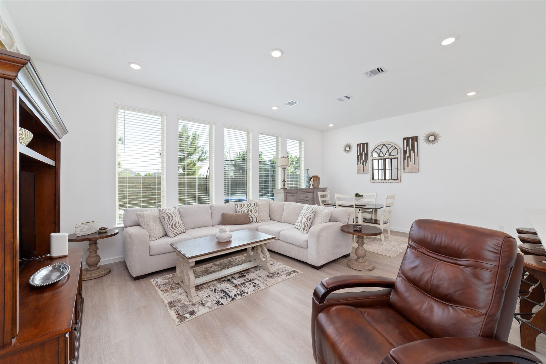 Large windows fill the family room with natural light, while the open floor plan allows for easy interaction between the living, dining, and kitchen spaces.