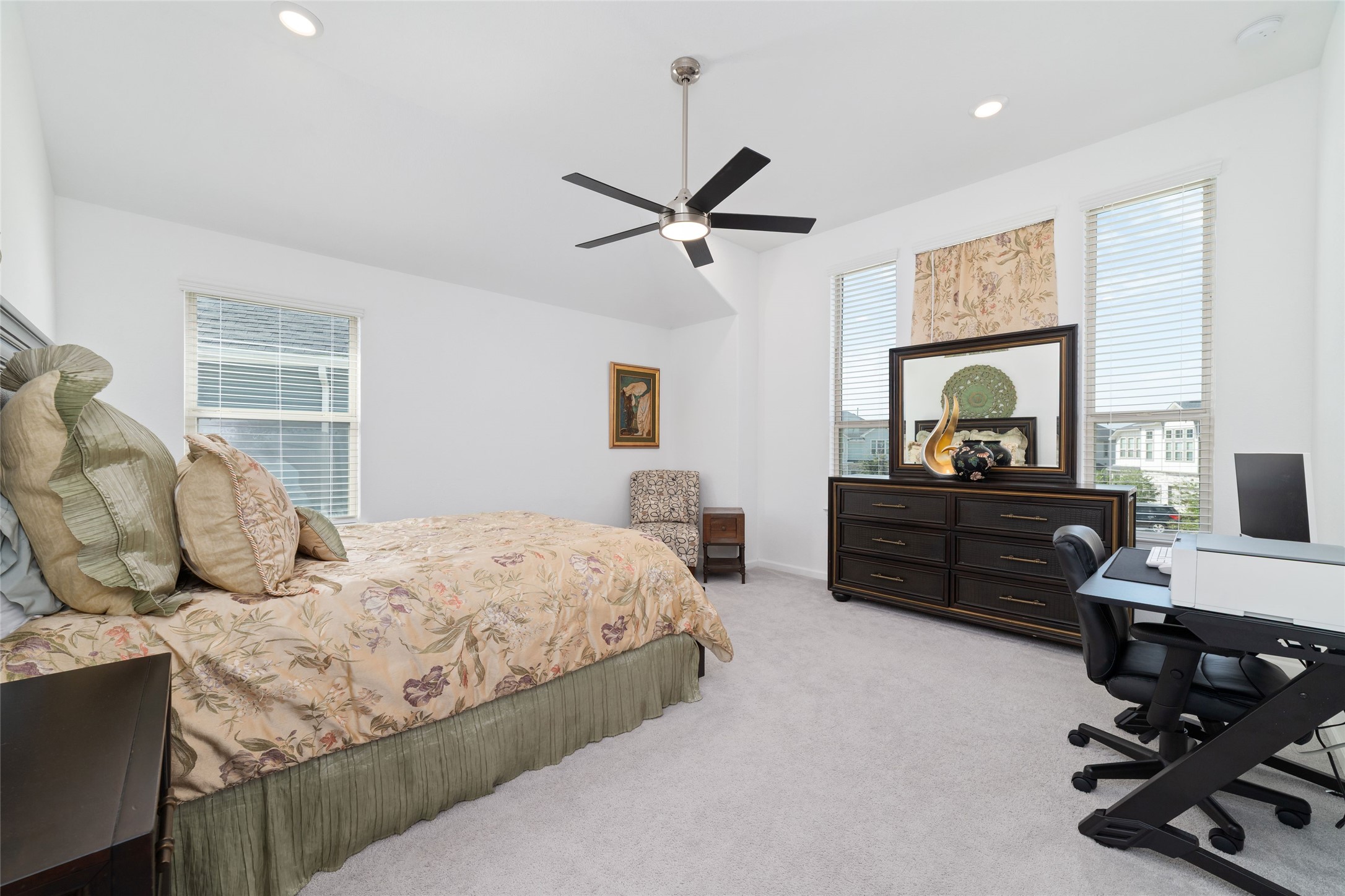 Another view of the primary suite highlights its comfortable proportions, multiple windows, and inviting atmosphere.