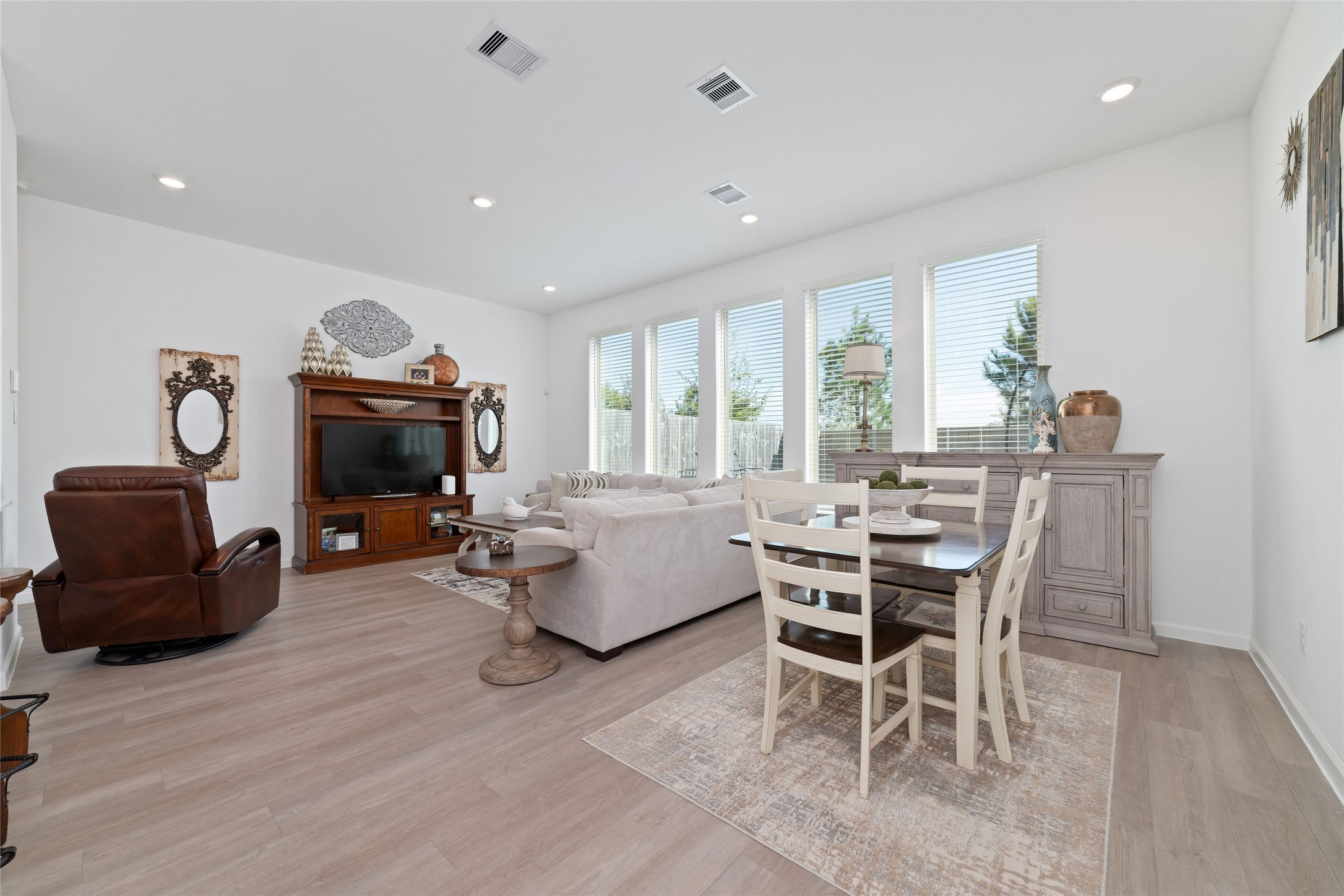 Enjoy a spacious family room featuring large windows, recessed lighting, neutral finishes, and an open layout designed for comfortable everyday living.