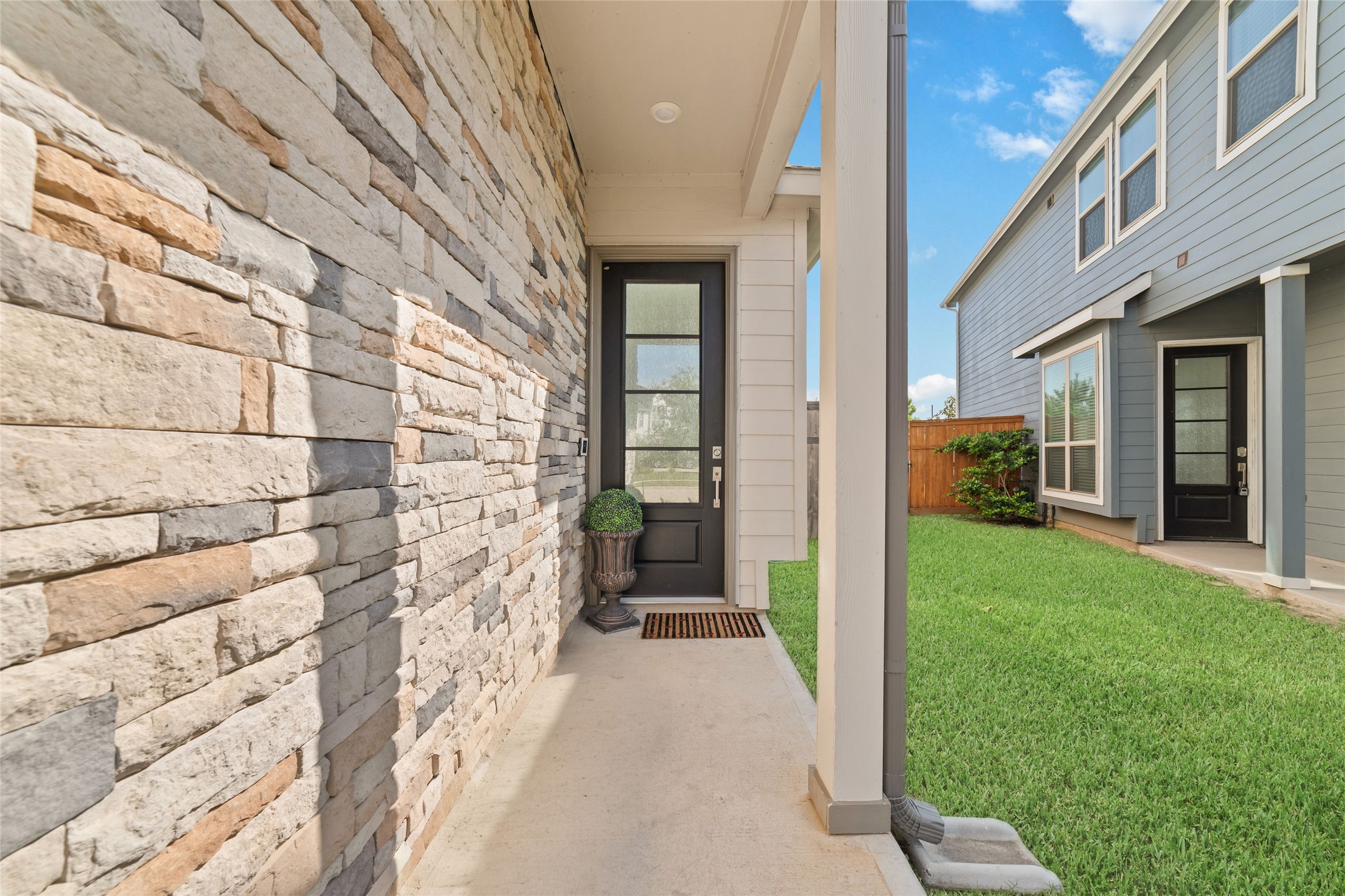 A covered front entry with beautiful stone detailing welcomes you home, offering a convenient walkway and easy access to the residence.