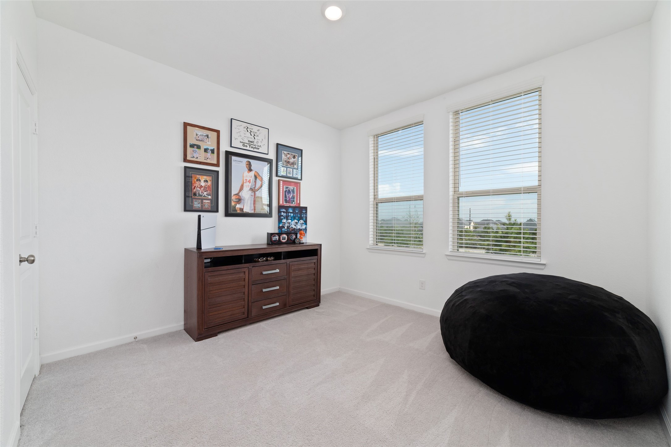 The additional secondary bedroom offers natural light, soft carpeting, and flexible space to accommodate a variety of needs.