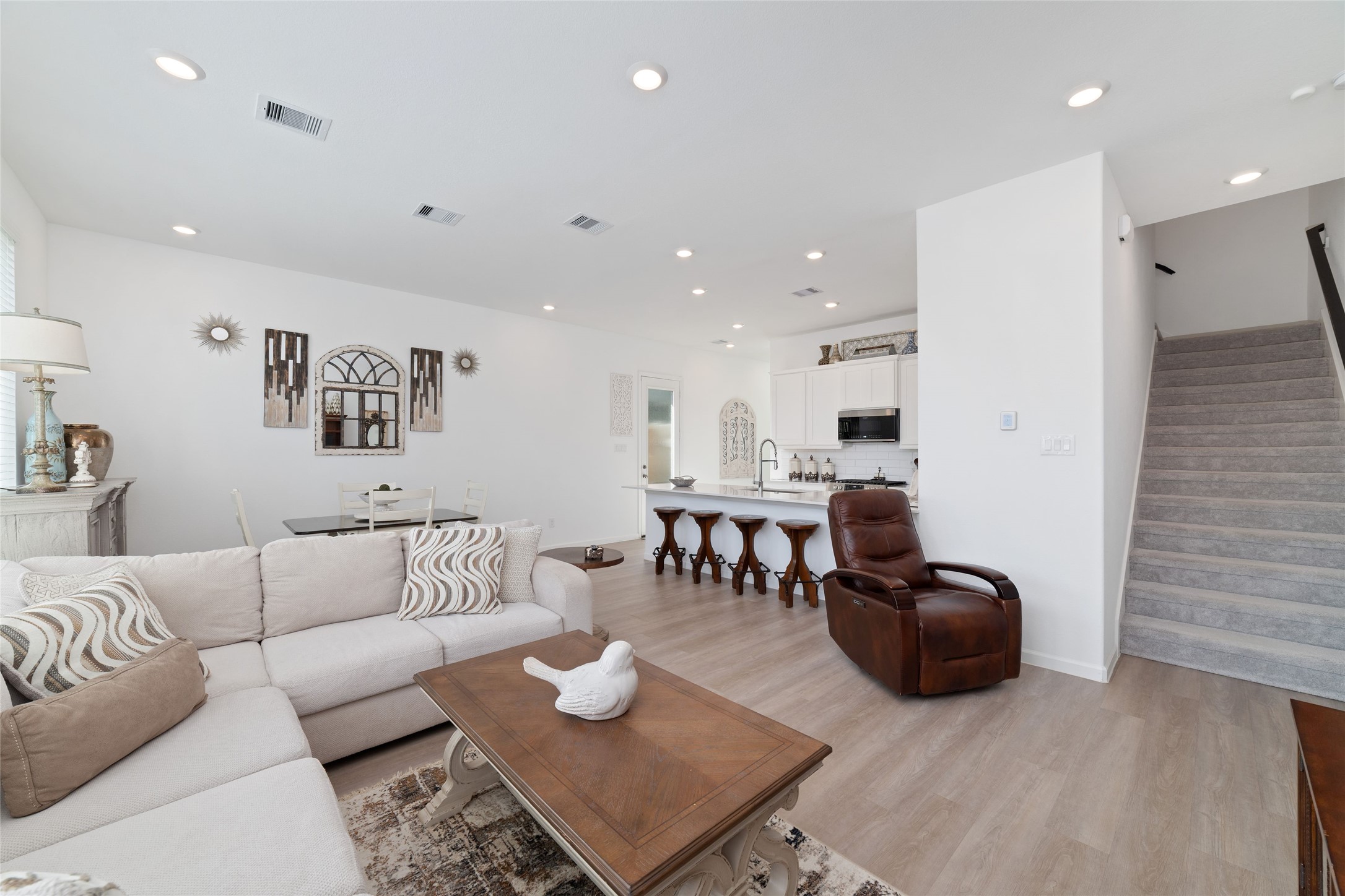 The thoughtfully designed main level offers a seamless flow between gathering spaces, with a staircase leading to the upstairs bedrooms and game room.