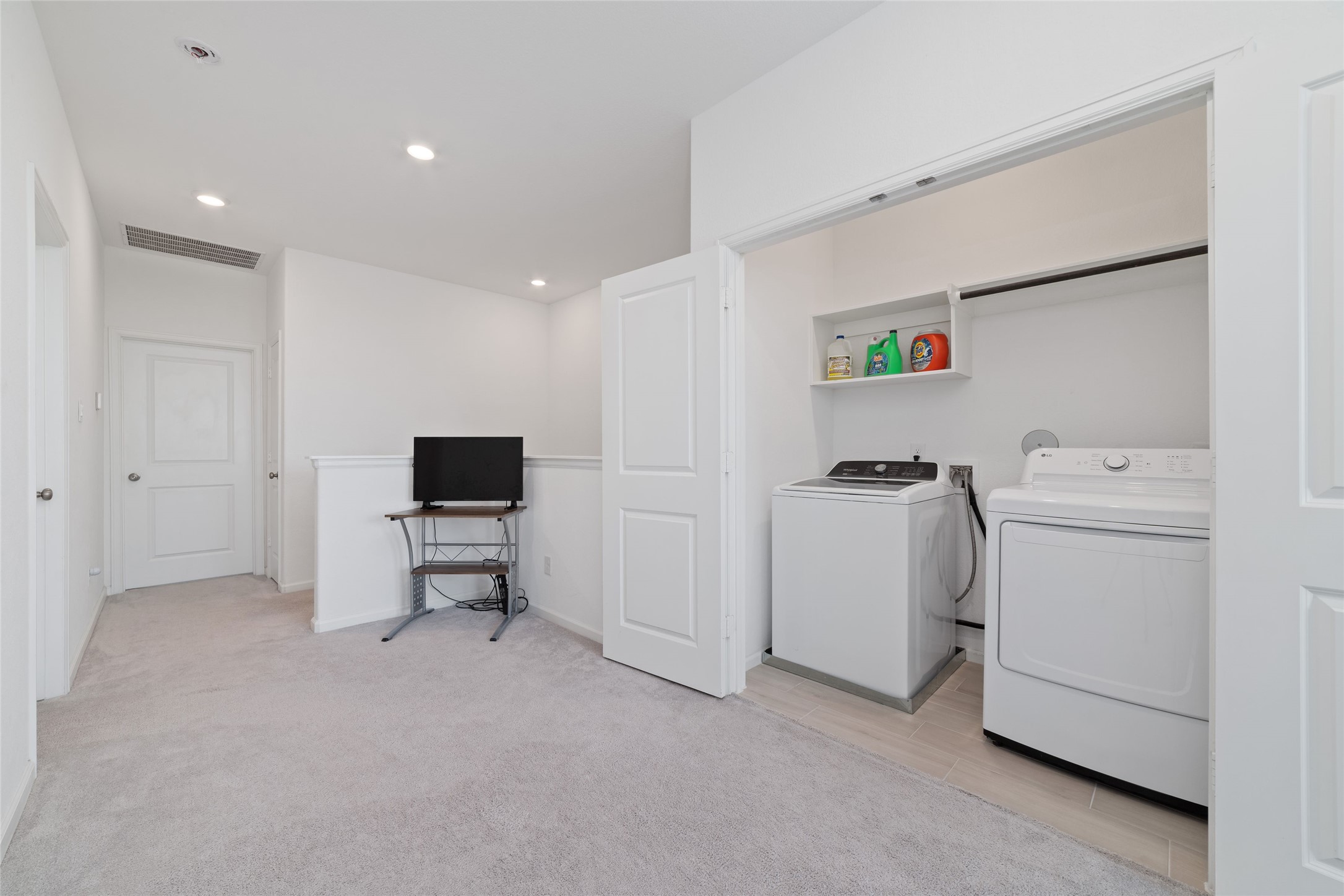 Conveniently located inside the home, the spacious utility room provides washer and dryer connections, additional cabinetry, and shelving for storage and organization.