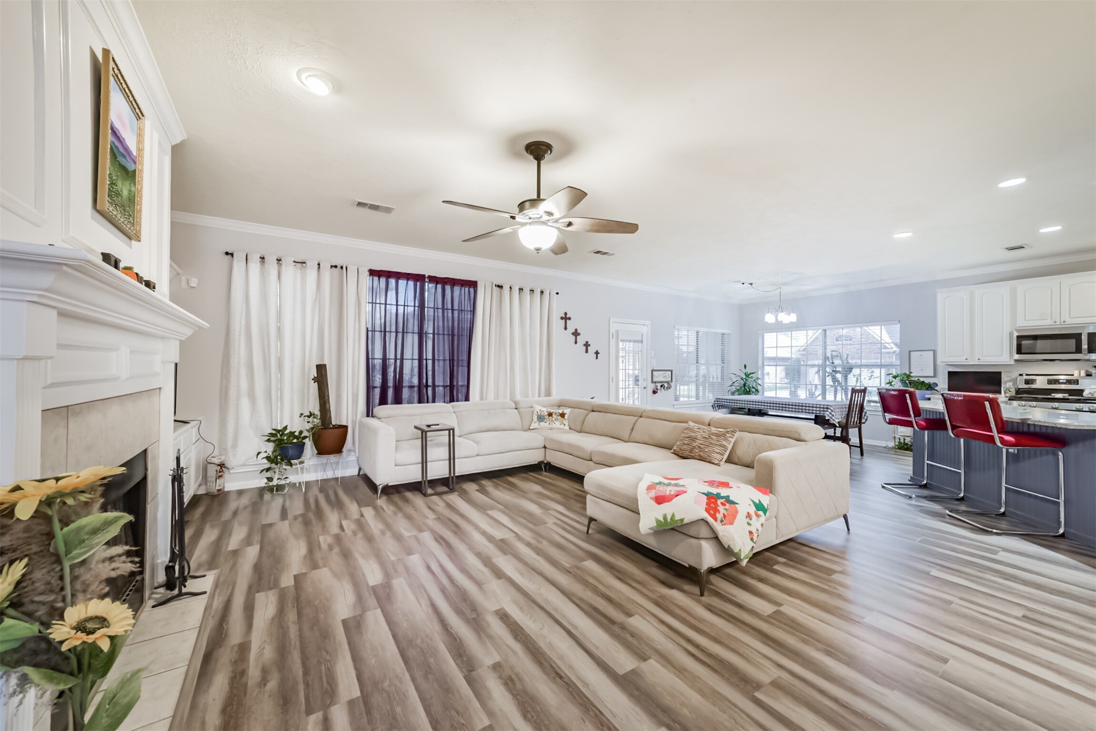 This open-concept home features a spacious family room that flows seamlessly into the kitchen and breakfast room. Recessed lighting and a ceiling fan with an integrated light fixture add both comfort and functionality.