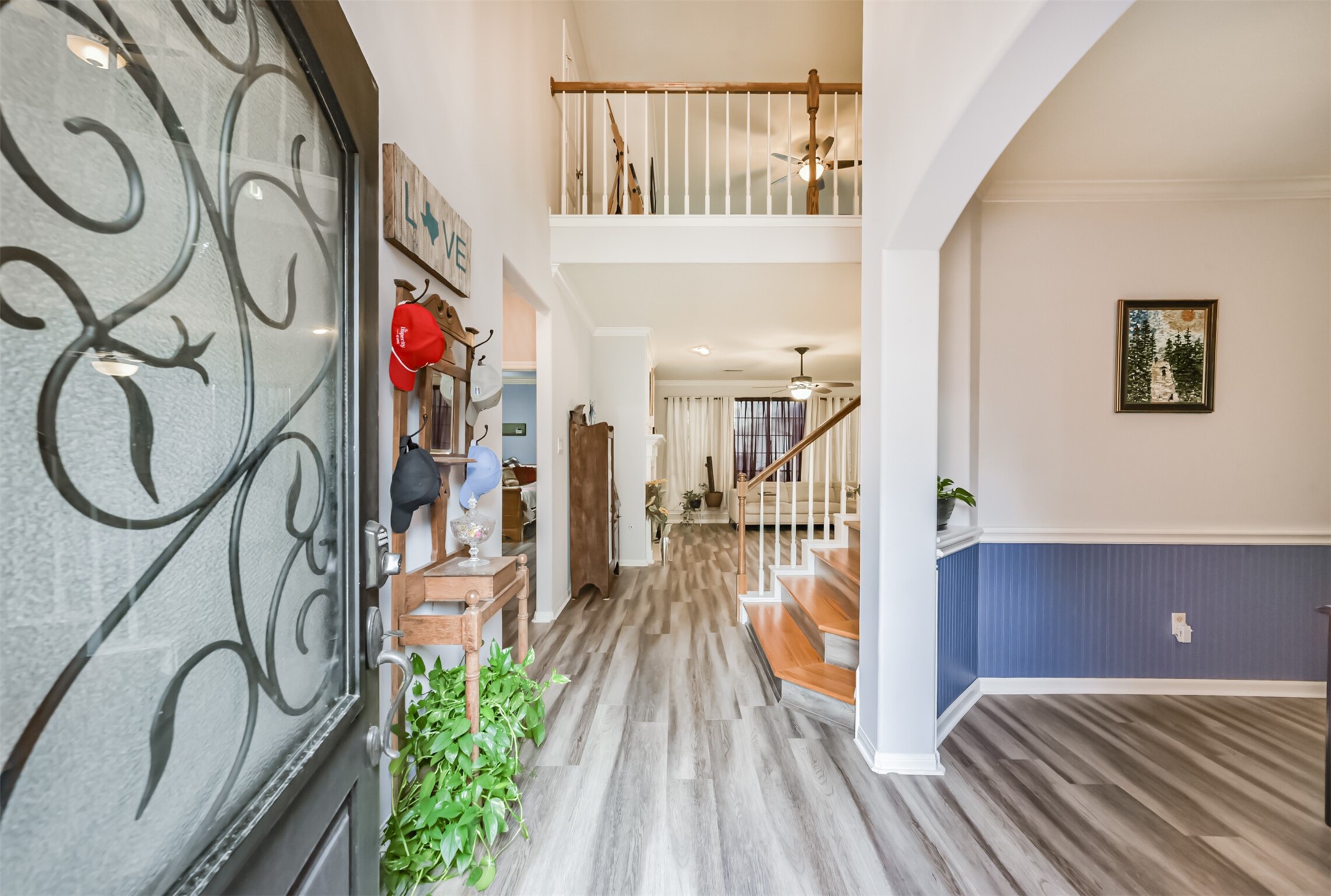 A soaring two-story foyer welcomes you with extensive wood-look vinyl plank flooring, while an elegant arched formal dining room sits just to the right.