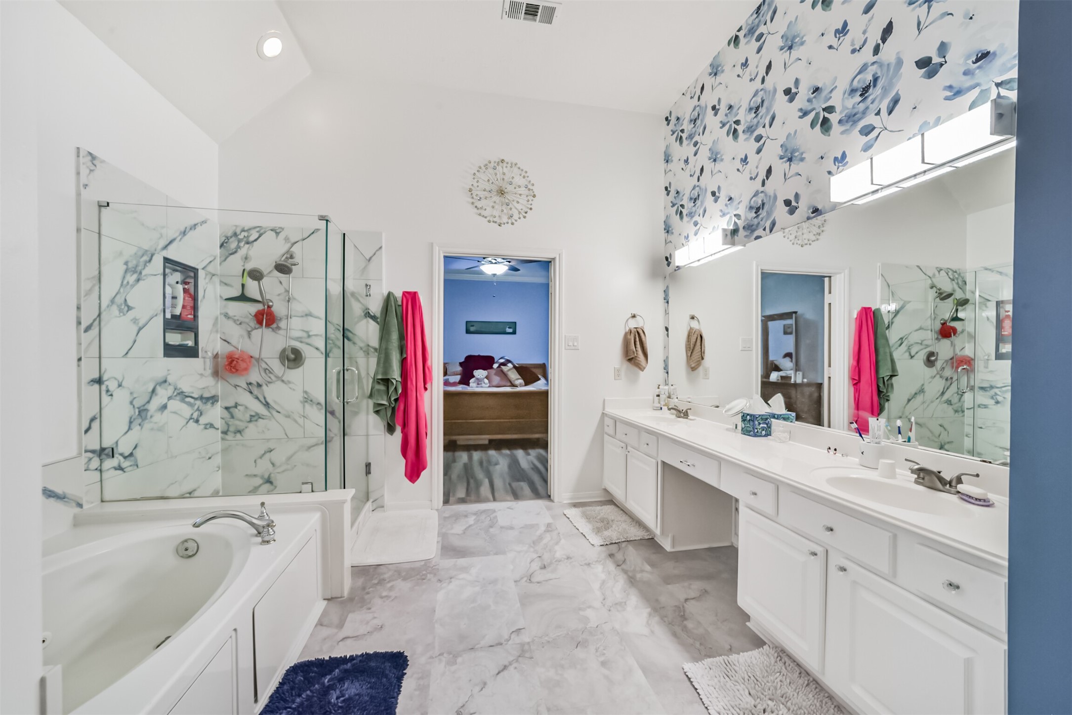 The primary bathroom features tiled flooring and a glass-enclosed, tiled shower.