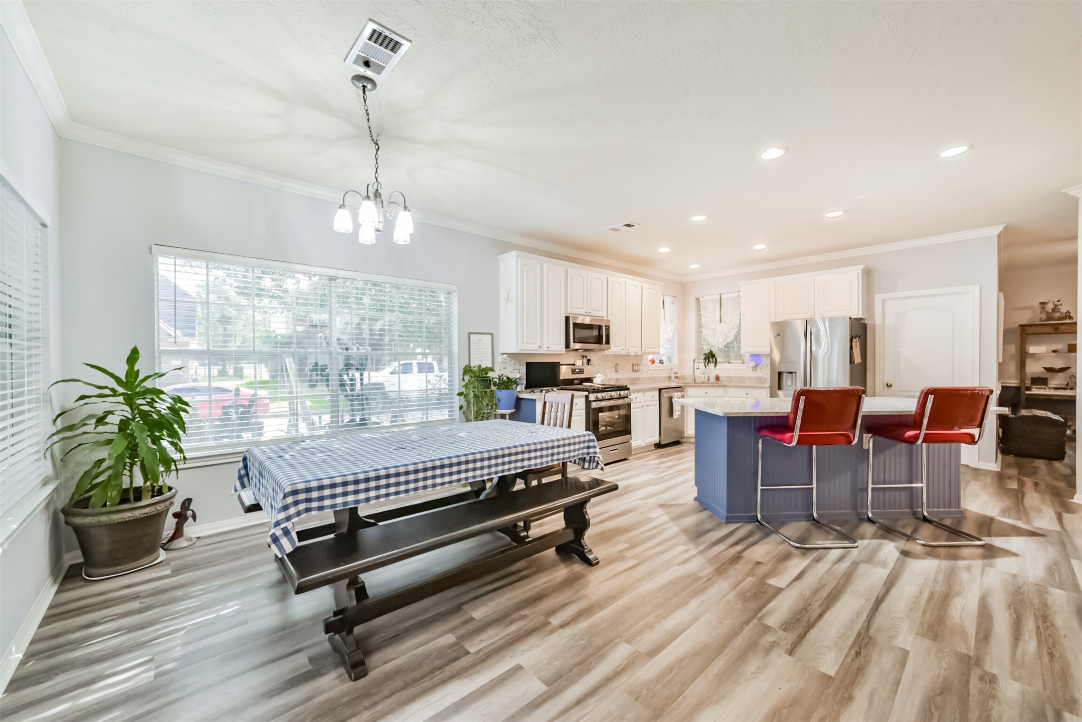 The spacious breakfast room, framed by two sets of windows, is ideal for informal dining. The island kitchen, complete with a breakfast bar, can also be viewed from here.