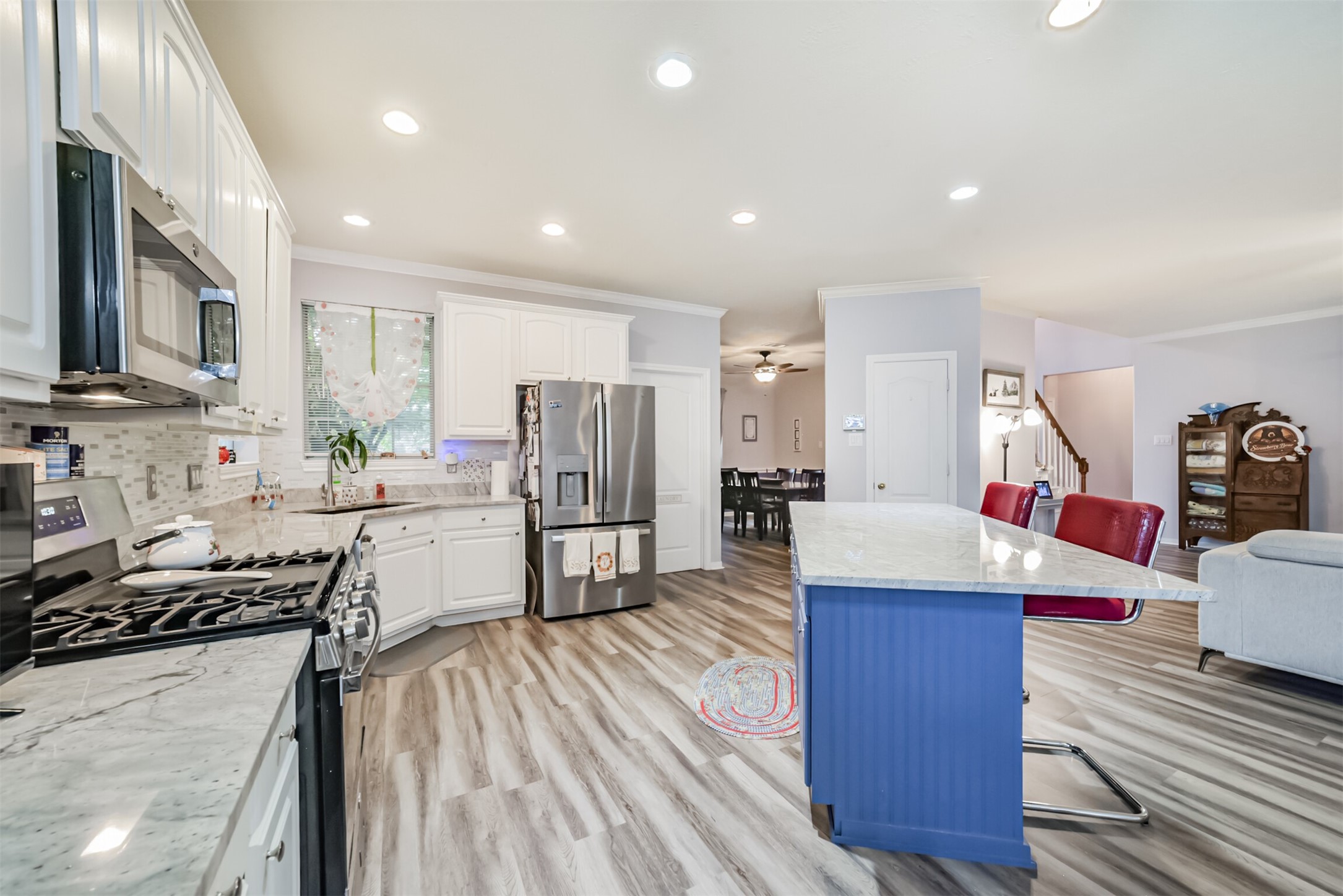 Kitchen featuring a gas oven and stove, a corner undermount sink beneath a window, and built-in stainless steel appliances.
