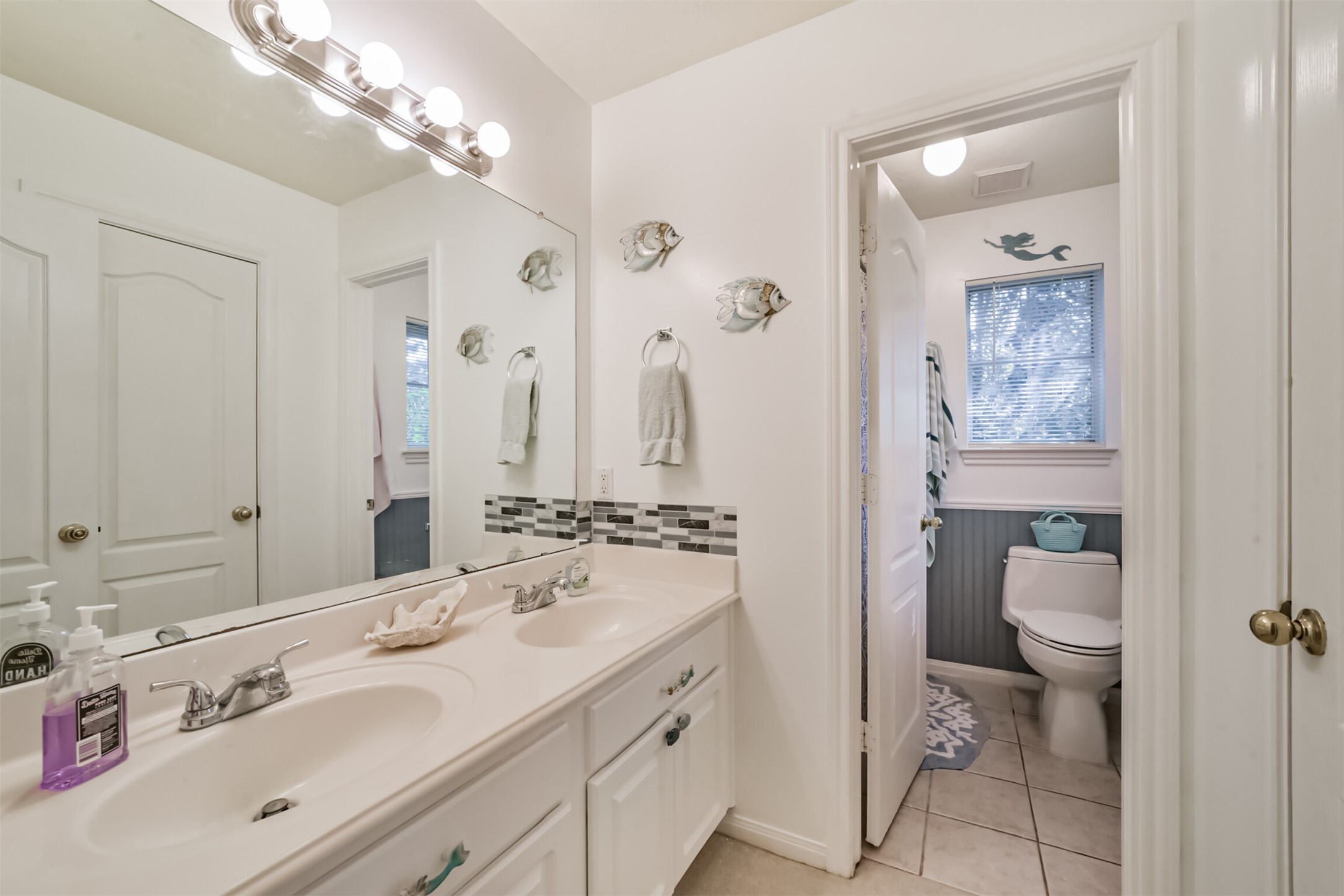 The upstairs full bathroom features a cultured marble vanity with dual sinks and a private water closet.