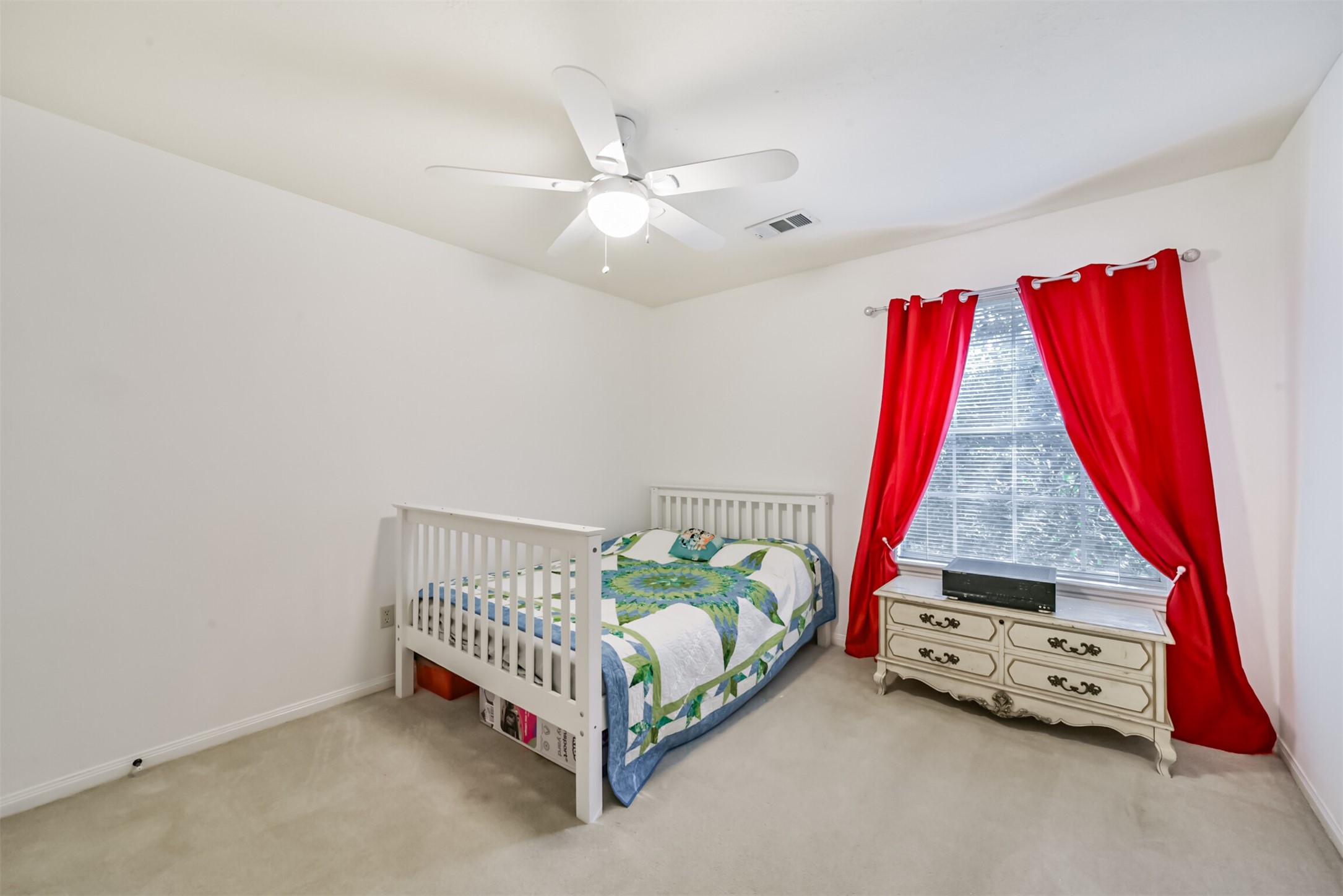 Upstairs bedroom 3 features a ceiling fan with an integrated light fixture, along with blinds and curtains for window treatments.