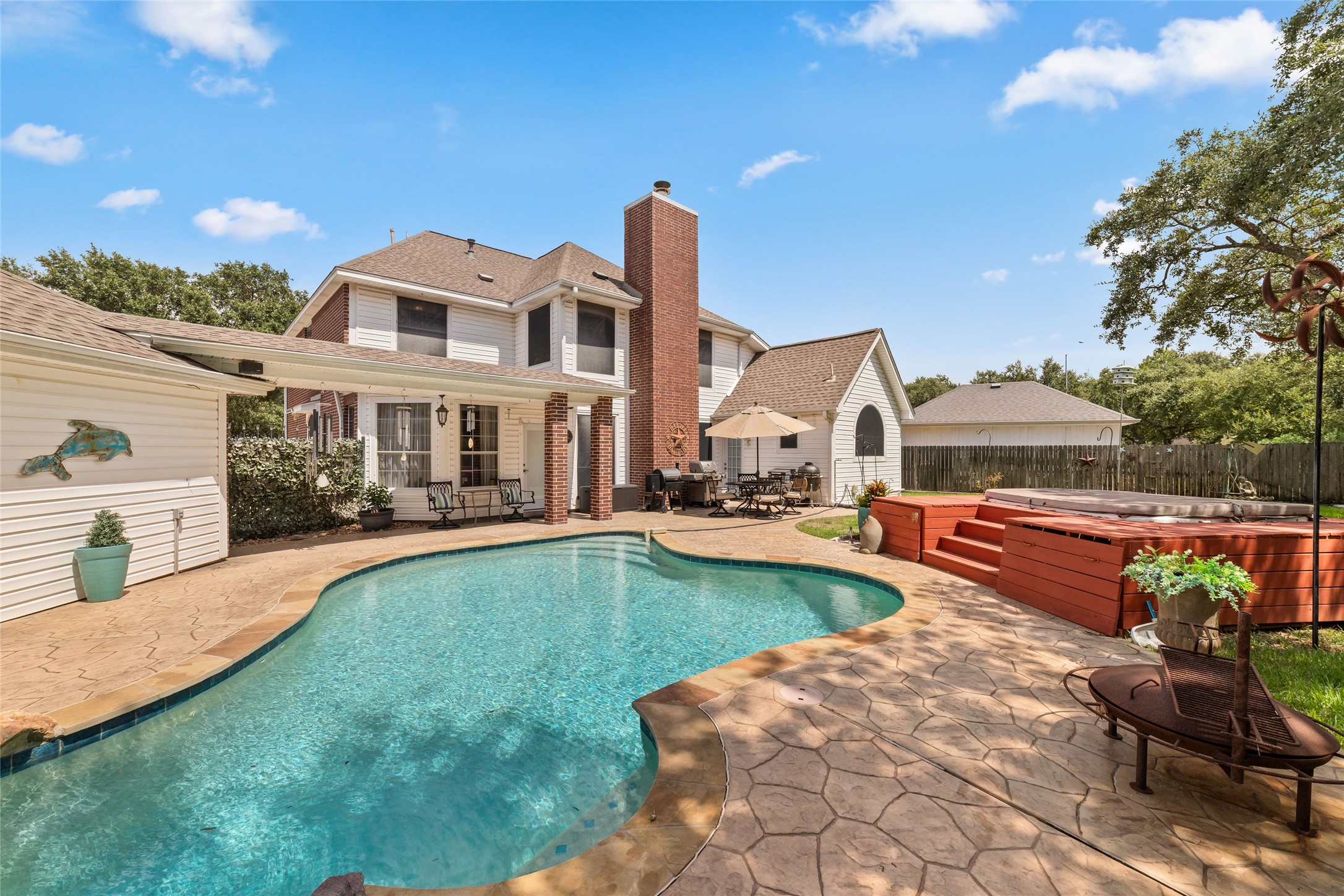 Rear exterior view showing the pool, covered patio, back of the home, and outdoor entertaining areas.