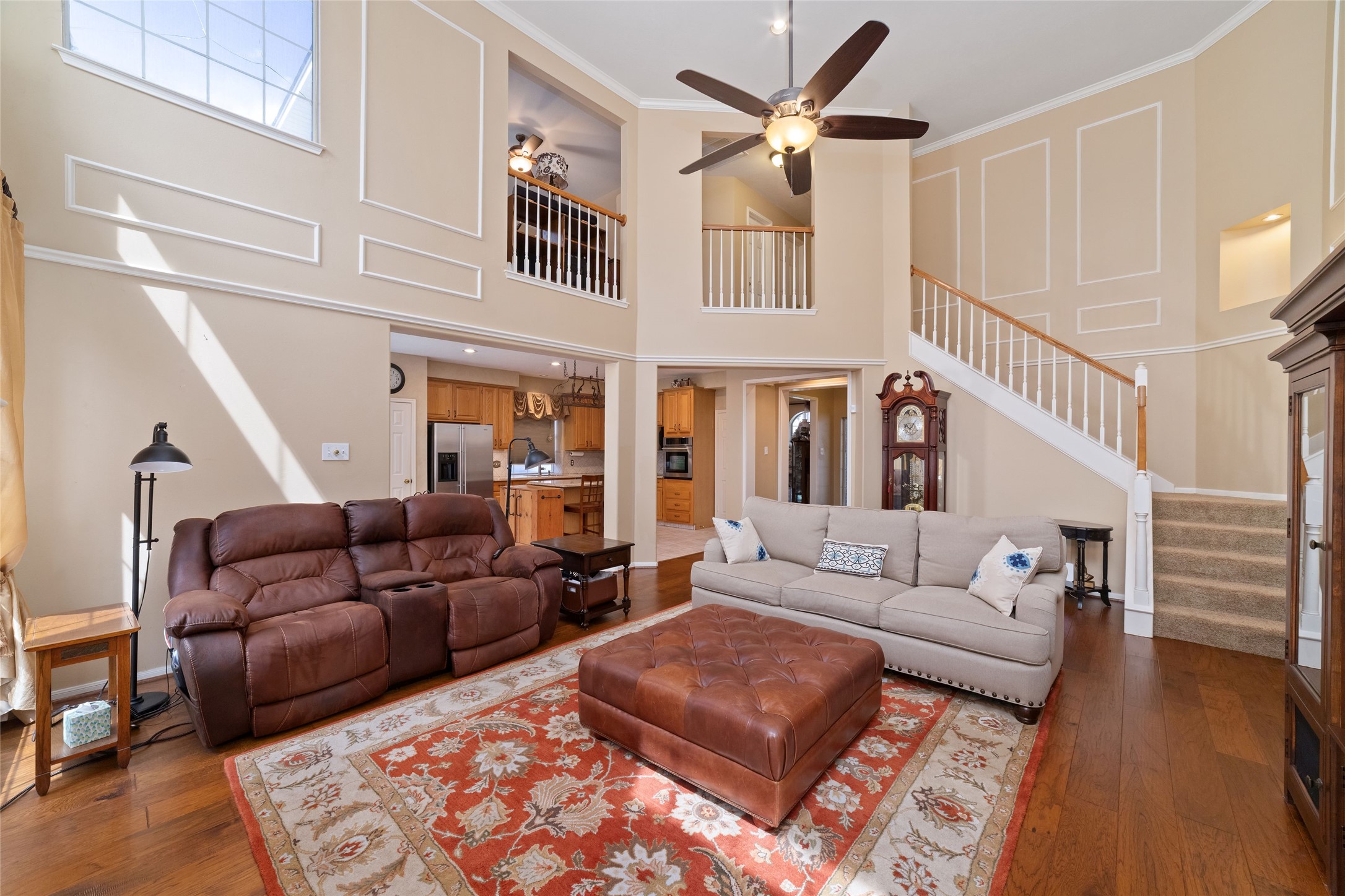 Another view of the living room showing the open staircase, second-floor overlook, and generous seating area.