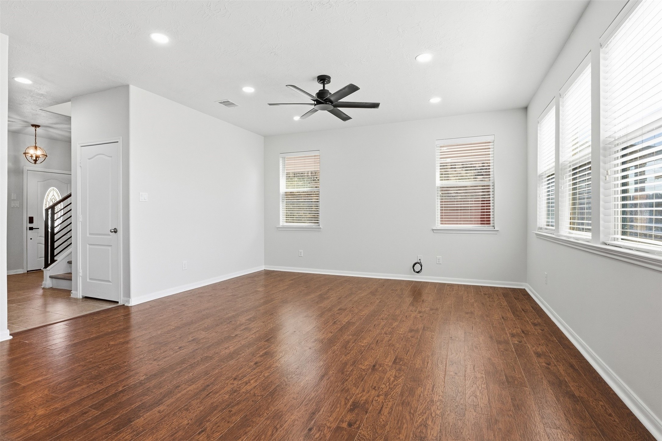 Multiple wide windows provide abundant natural light, while the open layout offers ample space for a variety of furniture arrangements.