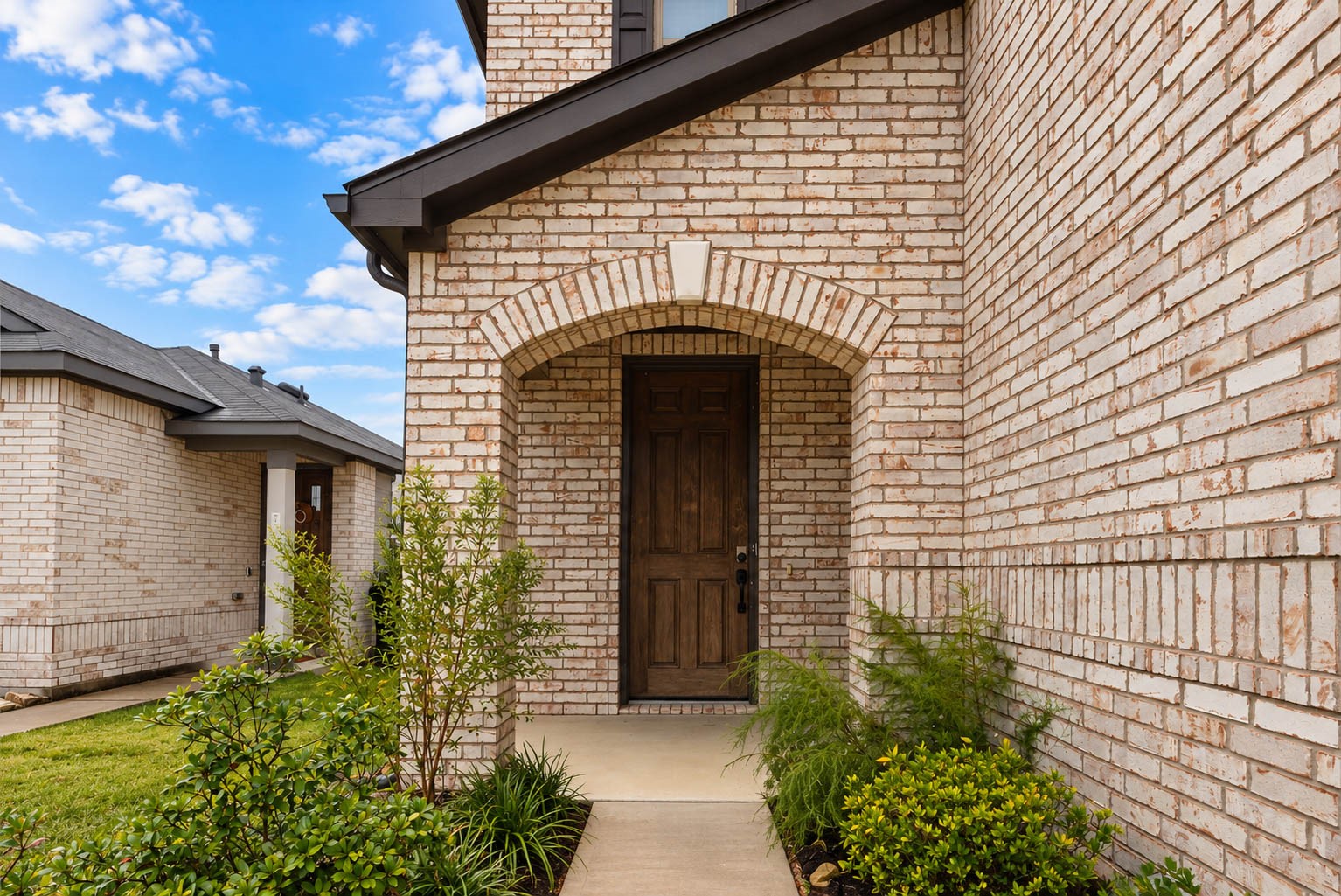 Showcasing timeless architectural charm, the home's striking brick faade, elegant arched entryway, & beautifully manicured landscaping create exceptional curb appeal. A welcoming covered front porch adds the perfect finishing touch, making a stunning first impression!