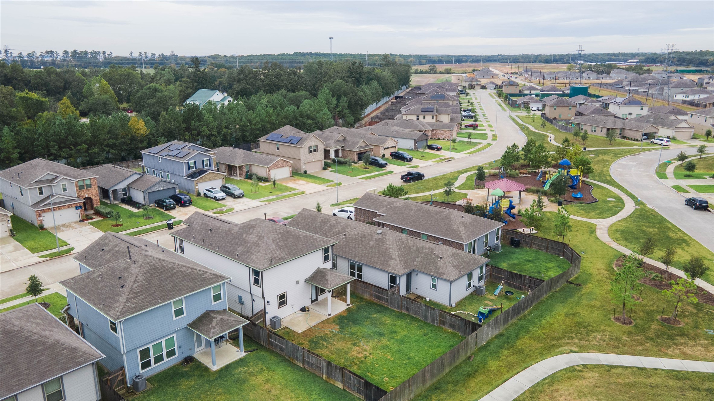 Location is everything! This aerial view highlights the home's prime proximity to the neighborhood playground, which features vibrant play structures & shaded seating areas.