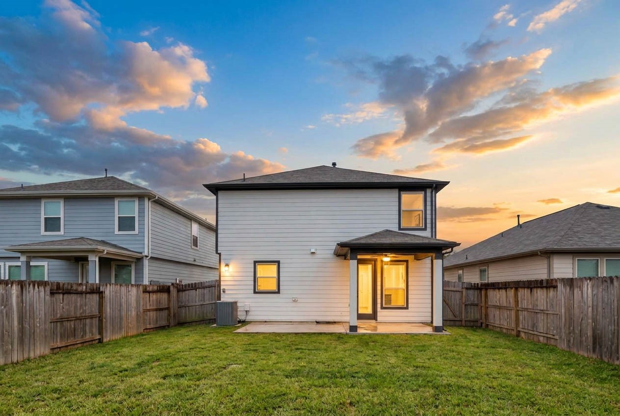 As the sun sets, this beautiful backyard retreat takes on a warm & inviting glow! The covered patio, softly illuminated windows, & expansive fully fenced lawn create a peaceful setting for relaxing, entertaining, or enjoying beautiful Texas evenings beneath the colorful sunset sky.