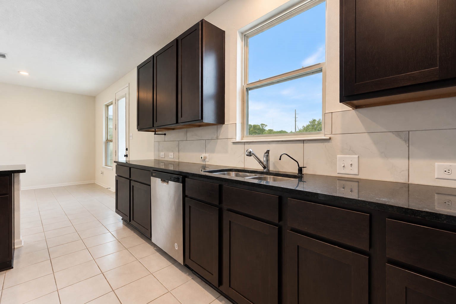 Recessed lighting & a large window above the double-basin sink fill the kitchen with natural light, while the thoughtfully designed layout flows effortlessly into the adjoining dining area, with convenient access to the backyard & covered patio.
