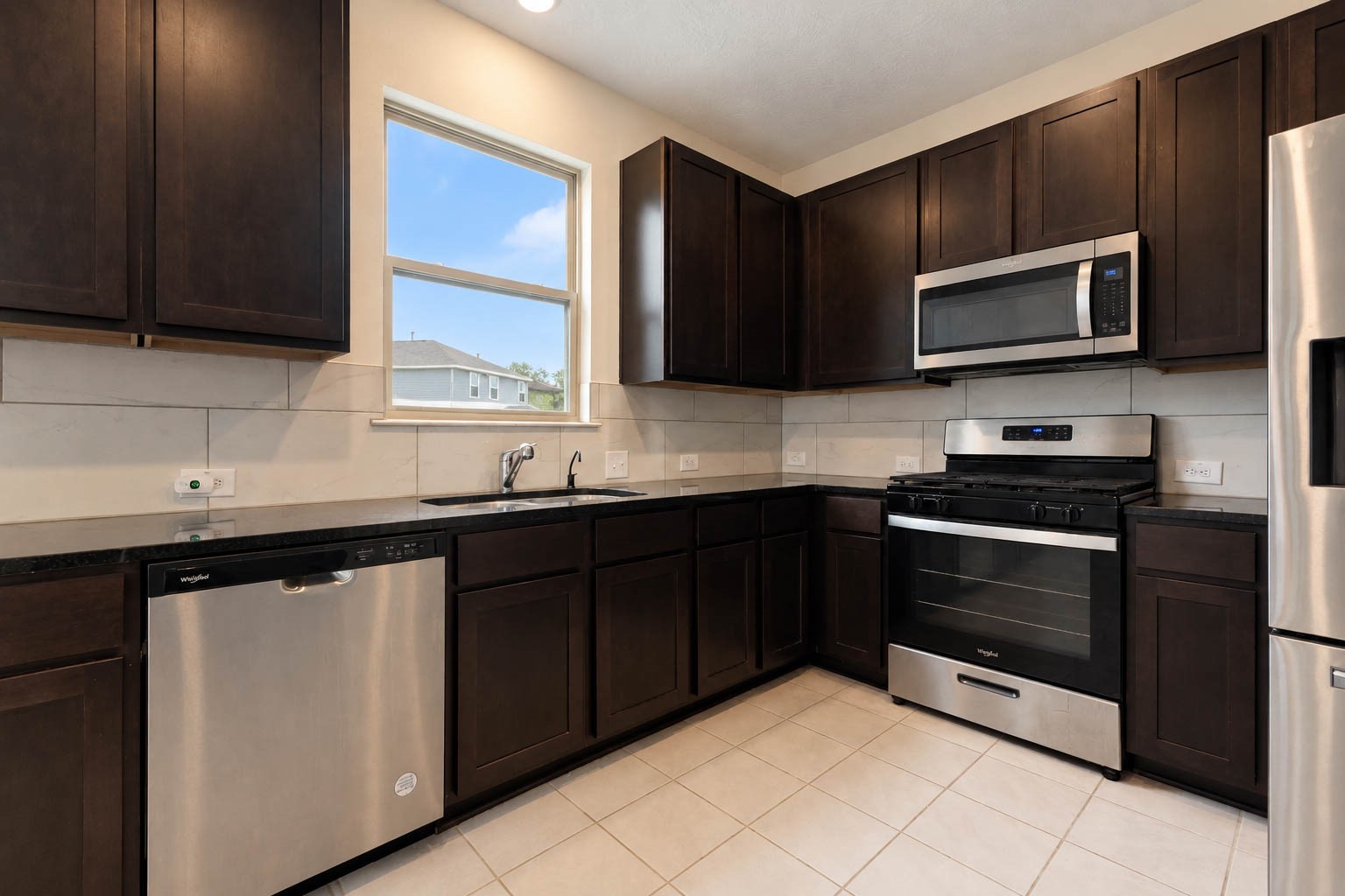 A suite of sleek stainless steel appliances, including a gas range, built-in microwave, & dishwasher, beautifully complements the kitchen's stylish finishes while offering everyday convenience & functionality.