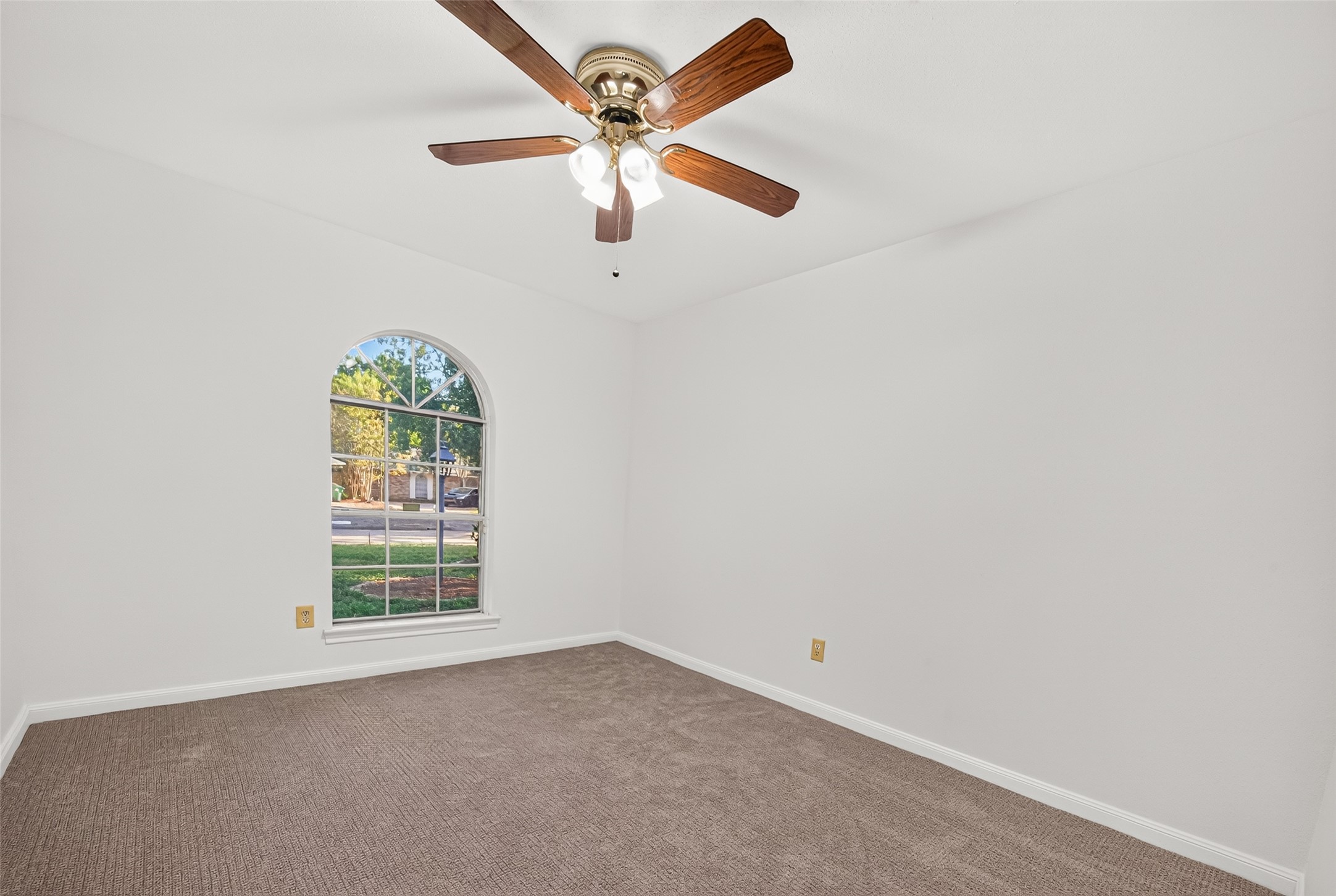 Plush new carpet, fresh paint and a beautiful arched window adds architectural charm while filling the room with natural light and offering a lovely view of the tree-lined front yard.